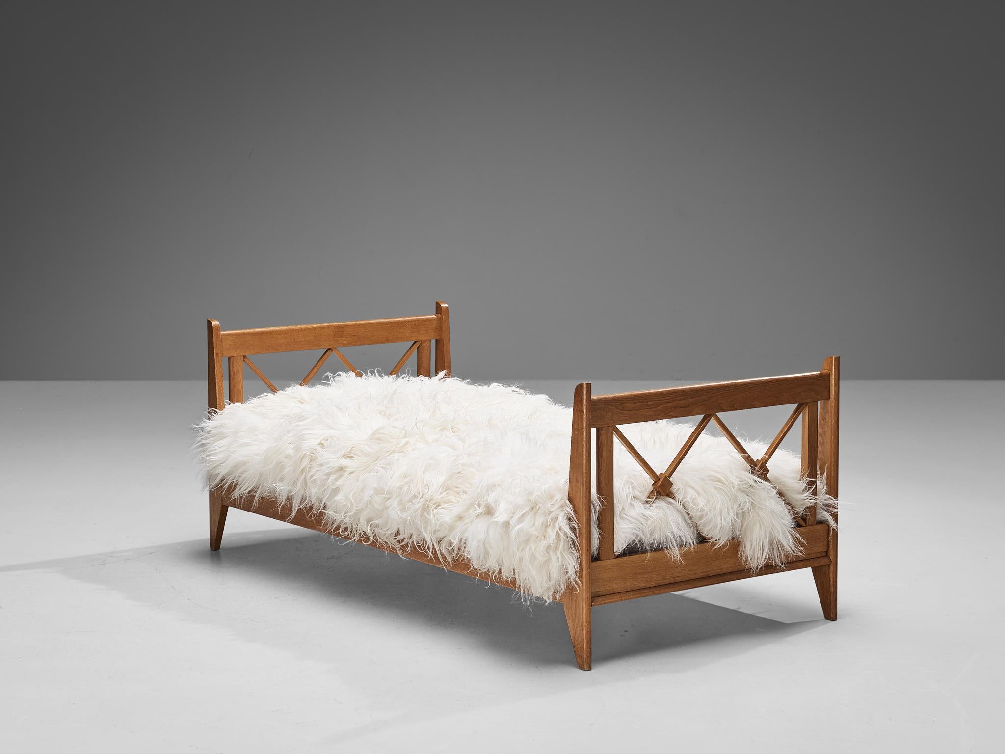 Single bed, oak, France, 1950s.

A beautifully made single bed in oakwood. It shows amazing craftsmanship that is evident in the interlocking crosses in the head- and footboard of the bed. The clean lines give, together with the choice of the
