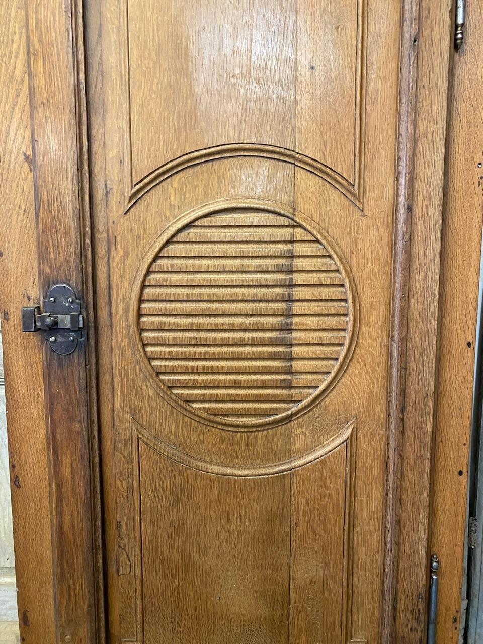 A lovely French Oak single door armoire or hall cupboard. Dating to the mid 19th Century and made of Oak. Nice circular decoration and the door and original catch. 
Someone has lined it and fitted glass shelves, this could easily be removed and