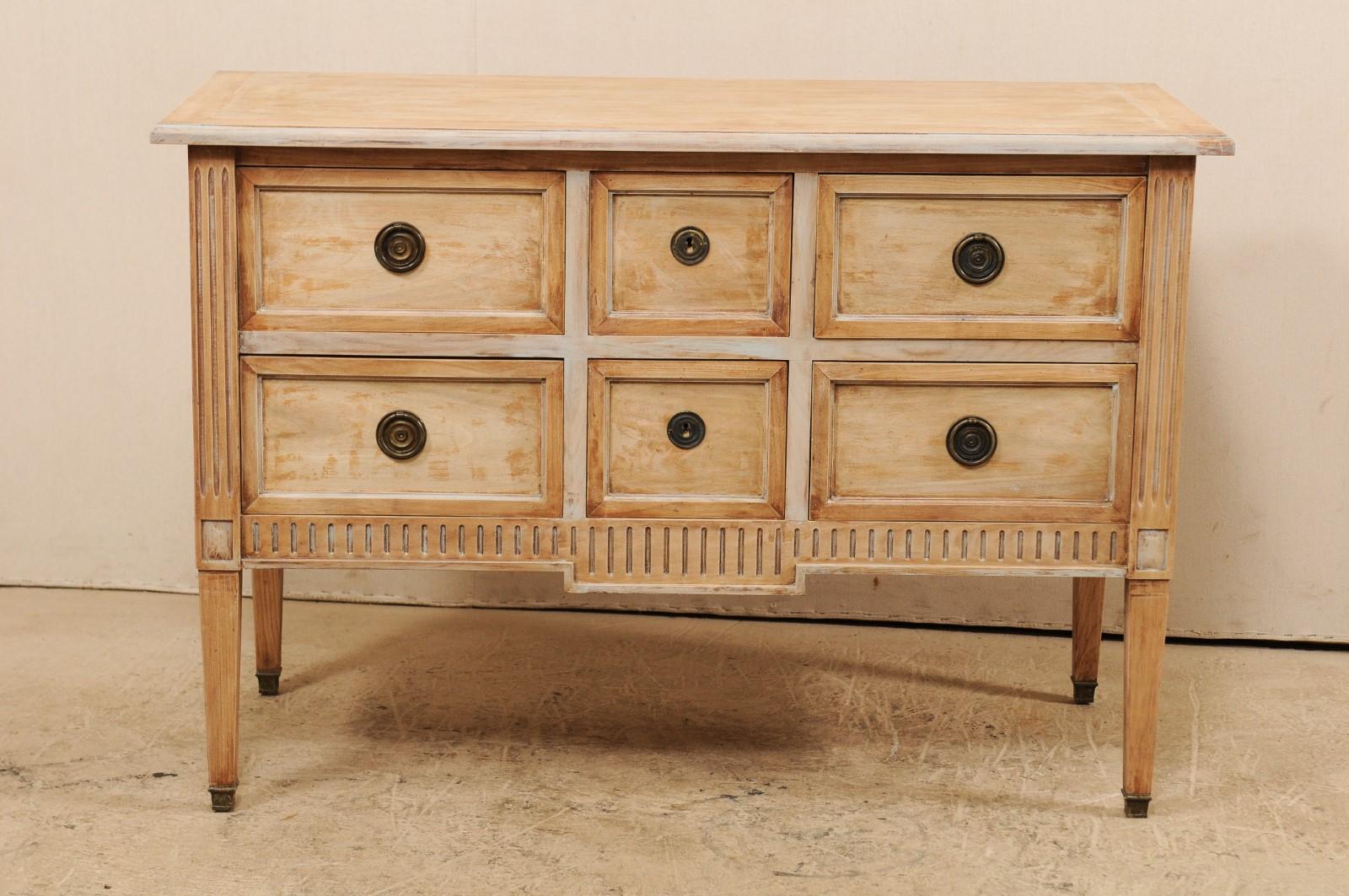 A French six-drawer chest from the mid-20th century. This vintage wooden chest from France features a rectangular-shaped top above six smaller-sized recessed panel drawers, flanked with fluted side-posts. There are two square shaped center drawers,