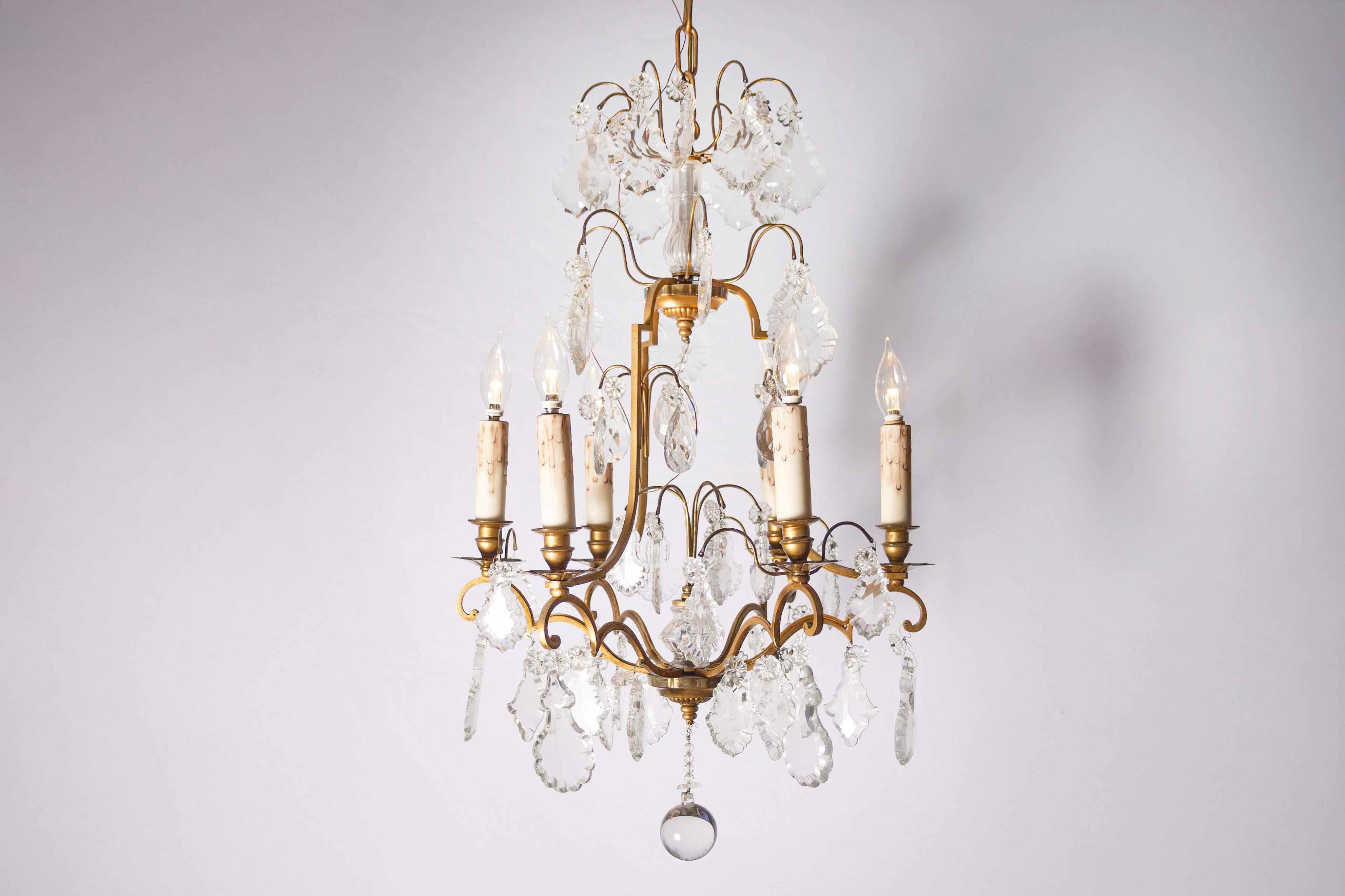 Lampadario francese a sei luci in cristallo della fine del XIX secolo, con armatura in ottone e colonna in cristallo. Nato in Francia negli ultimi anni del XIX secolo, questo delizioso lampadario presenta una struttura in ottone ornata da una
