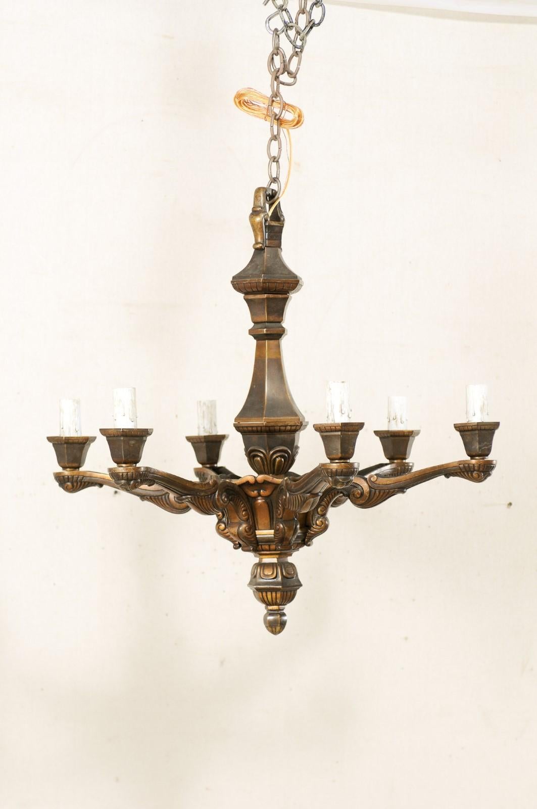 A French bronze chandelier with six-light from the mid-20th century. This vintage chandelier from France features a dark, nicely patinated and heavy bronze body. The central gallery supports the six arms, projecting outward in a circular fashion,