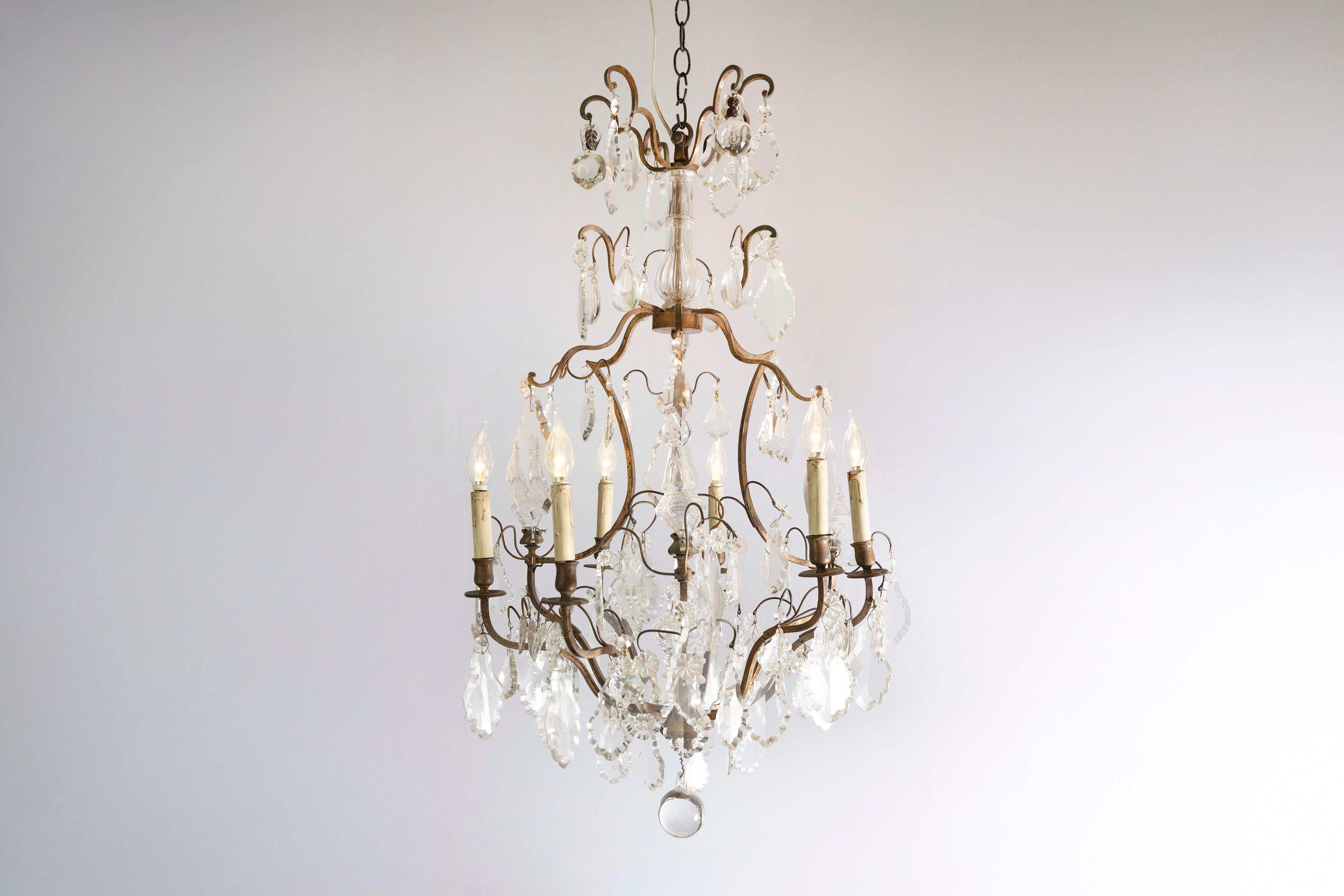 Lampadario francese a sei luci in cristallo della fine del XIX secolo, con armatura in ferro e obelischi. Nato in Francia durante l'epoca della Belle-Époque, questo raffinato lampadario a sei luci è caratterizzato da un'armatura in ferro a spirale