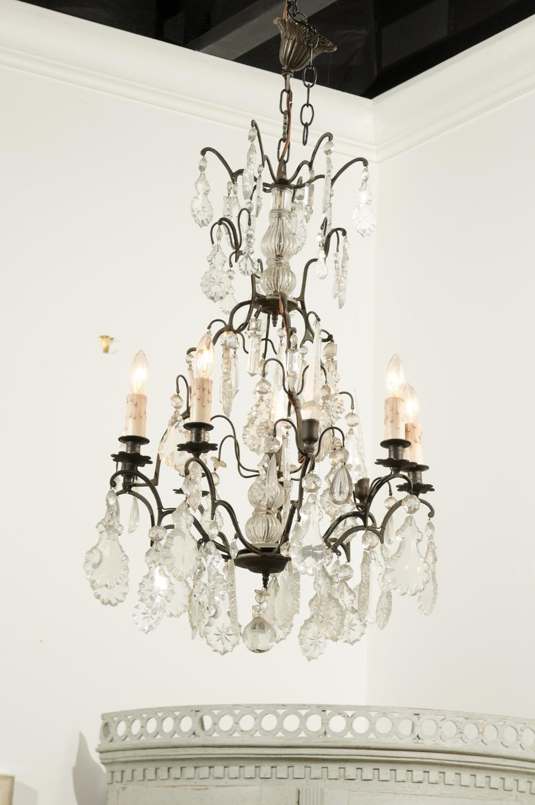 A French six-light crystal chandelier from the 19th century, with iron armature and obelisk motifs. This exquisite French crystal chandelier features a central crystal column, topped with petite scrolls supporting various pendeloques. The