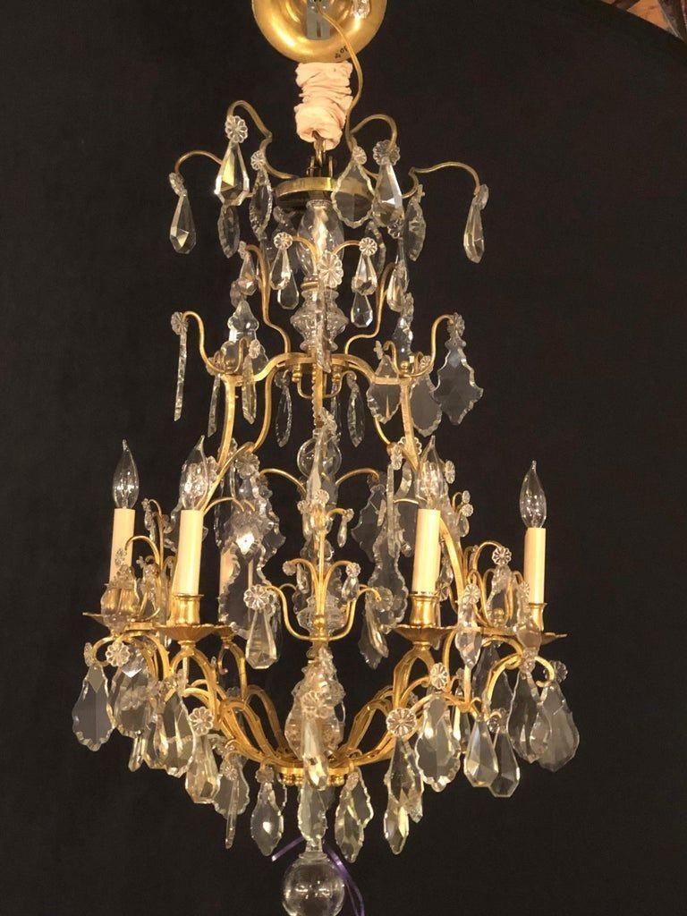 A fine six light cut crystal and brass chandelier newly wired. The center having glass column-form with brass supports leading to brass arms with a myriad of crystals and crystal rosettes. This finely detailed chandelier is in very fine condition