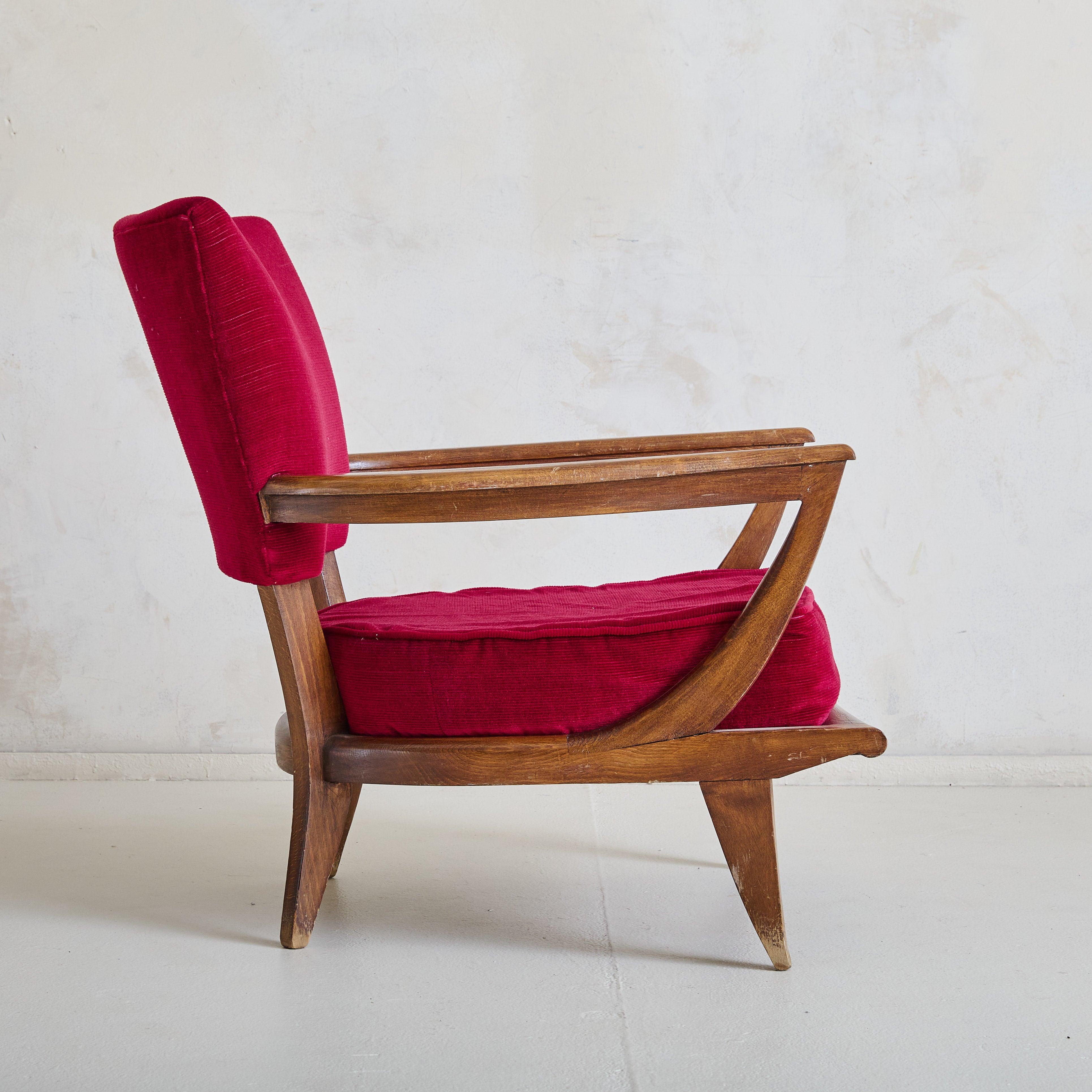 A rare model ‘SK40’ lounge chair designed by Etienne-Henri Martin and manufactured in 1952 by French company, Steiner. The chair has a solid wood frame and scalloped back rest. This chair is upholstered in vibrant red fabric that is soft to the