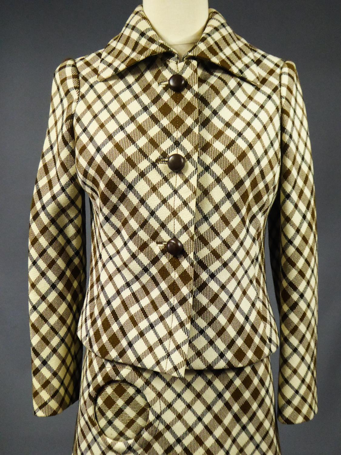 Circa 1968
France

Checked Skirt Suit in wool demi-Couture Christian Dior signed by Bérénice Haute Couture in Marseille and dating from the Modernist period of the late 1960s. Fitted jacket with front closure by three buttons in brown plastic and