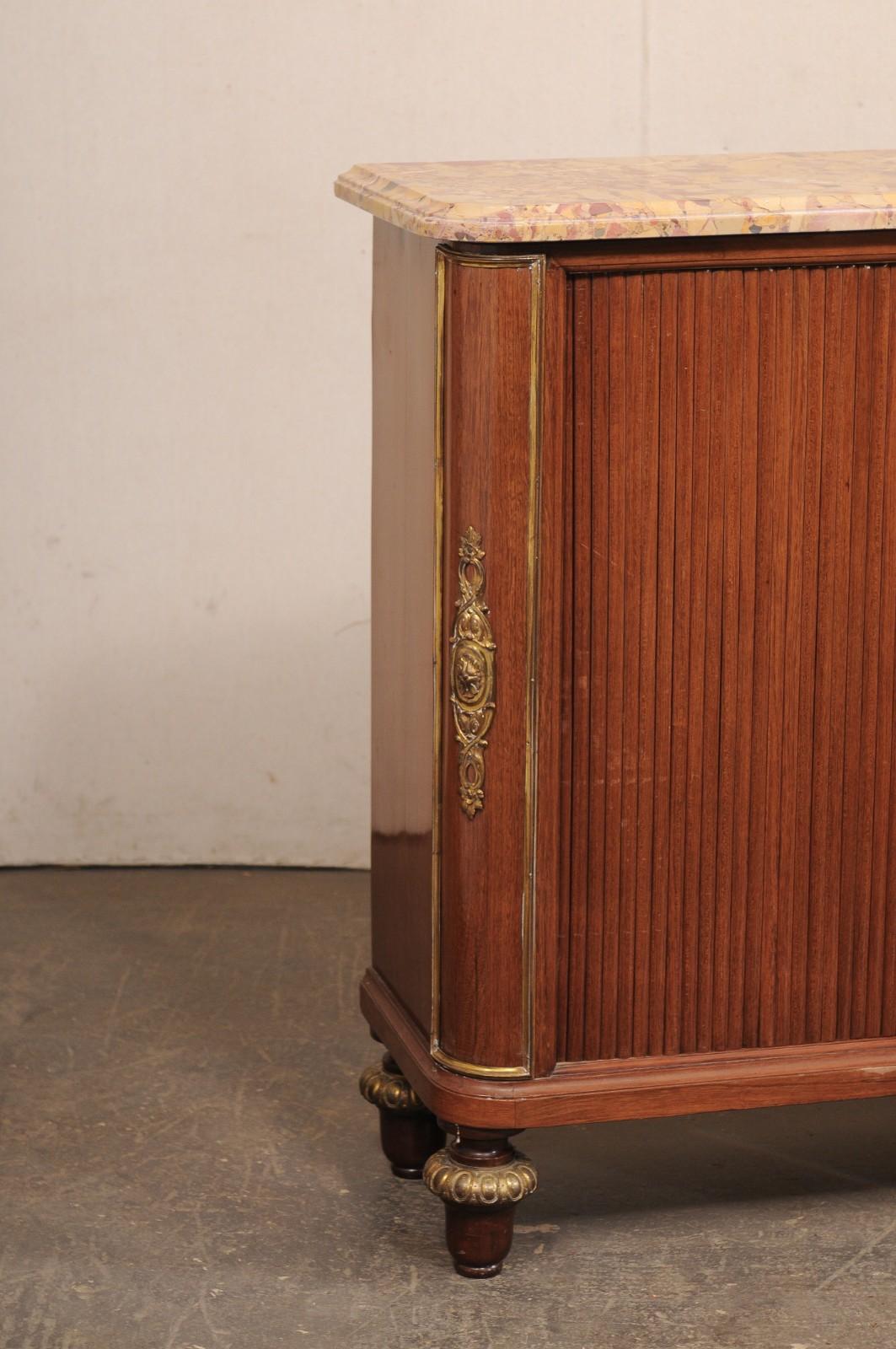 Una consolle francese con ante a tamburo e piano in marmo originale, risalente agli inizi del XX secolo. Questa cassapanca antica proveniente dalla Francia presenta il piano in marmo originale di forma rettangolare (con angoli anteriori arrotondati)