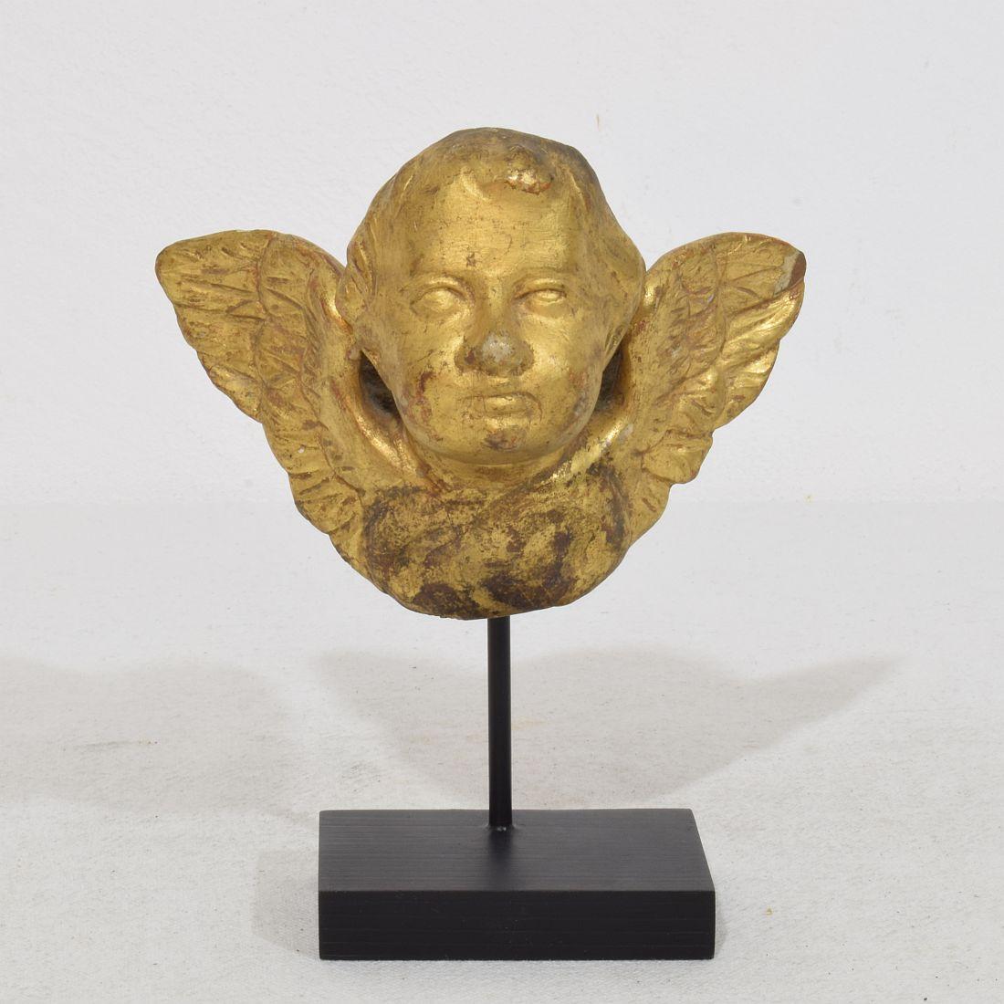 Wonderful small Hand carved winged angelhead with its original gilding.
Italy, circa 1750
Weathered.
Measurement here below inclusive the wooden base.
H:14cm  W:11,5cm D:7cm 