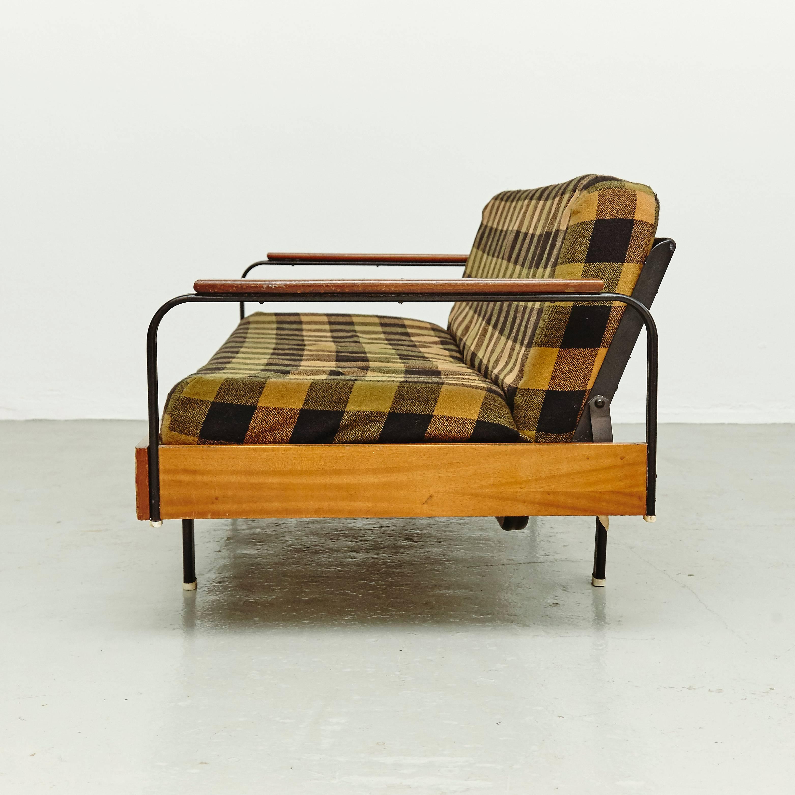 Sofa by unknown manufacturer in France, circa 1950, designed in the manner of Jean Prouve. 

Lacquered metal base and wood. 

The cushion are original.

In good original condition, with minor wear consistent with age and use, preserving a