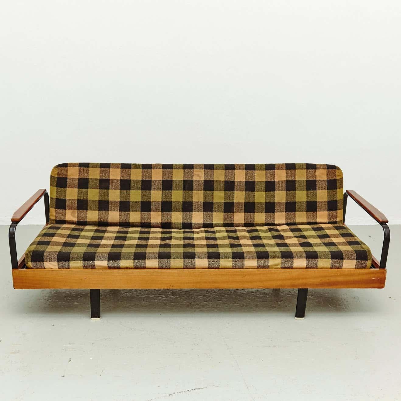 Sofa by unknown manufacturer in France, circa 1950, designed in the manner of Jean Prouve. 

Lacquered metal base and wood. 

The cushion are original.

In good original condition, with minor wear consistent with age and use, preserving a