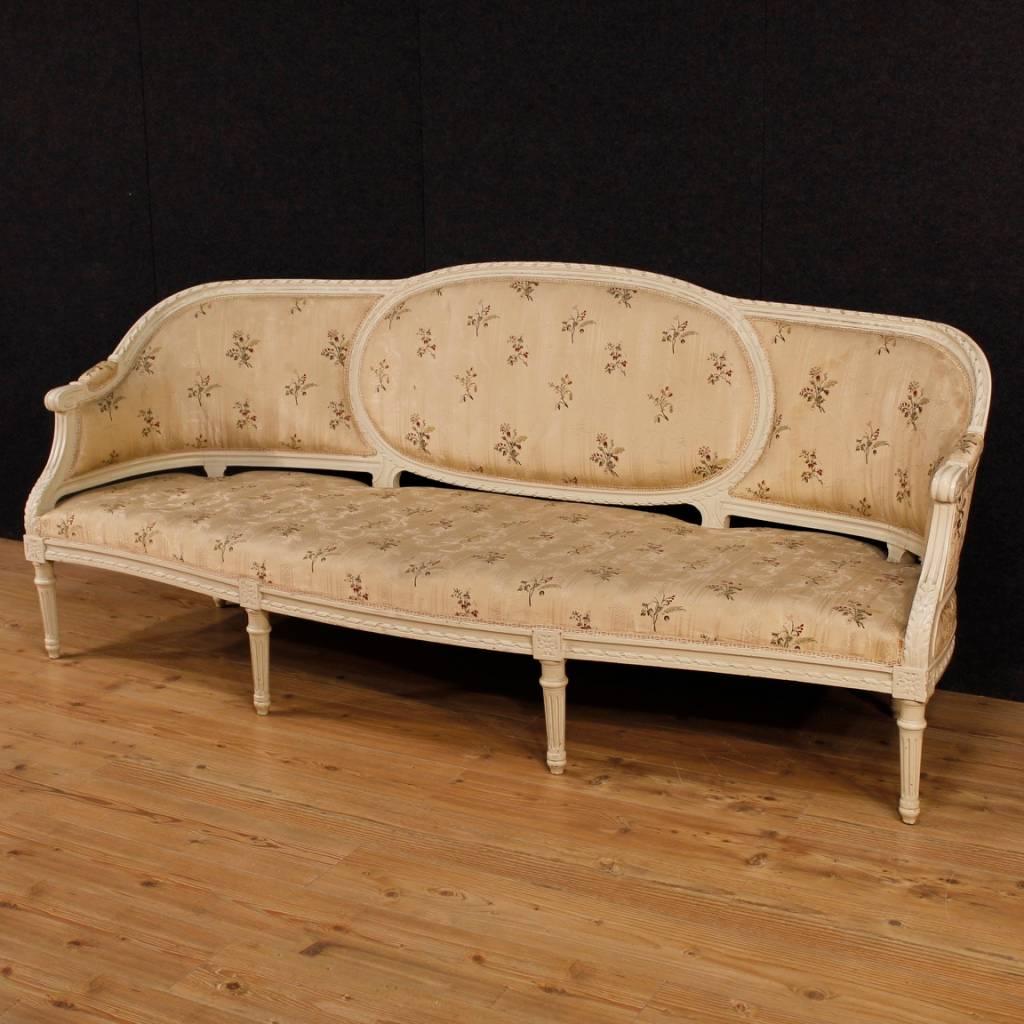 Great Louis XVI style sofa. French furniture from the mid-20th century in finely carved and lacquered wood, of beautiful decoration. Four-seat sofa, finished for the centre and covered with floral fabric in fair condition (with some stains).