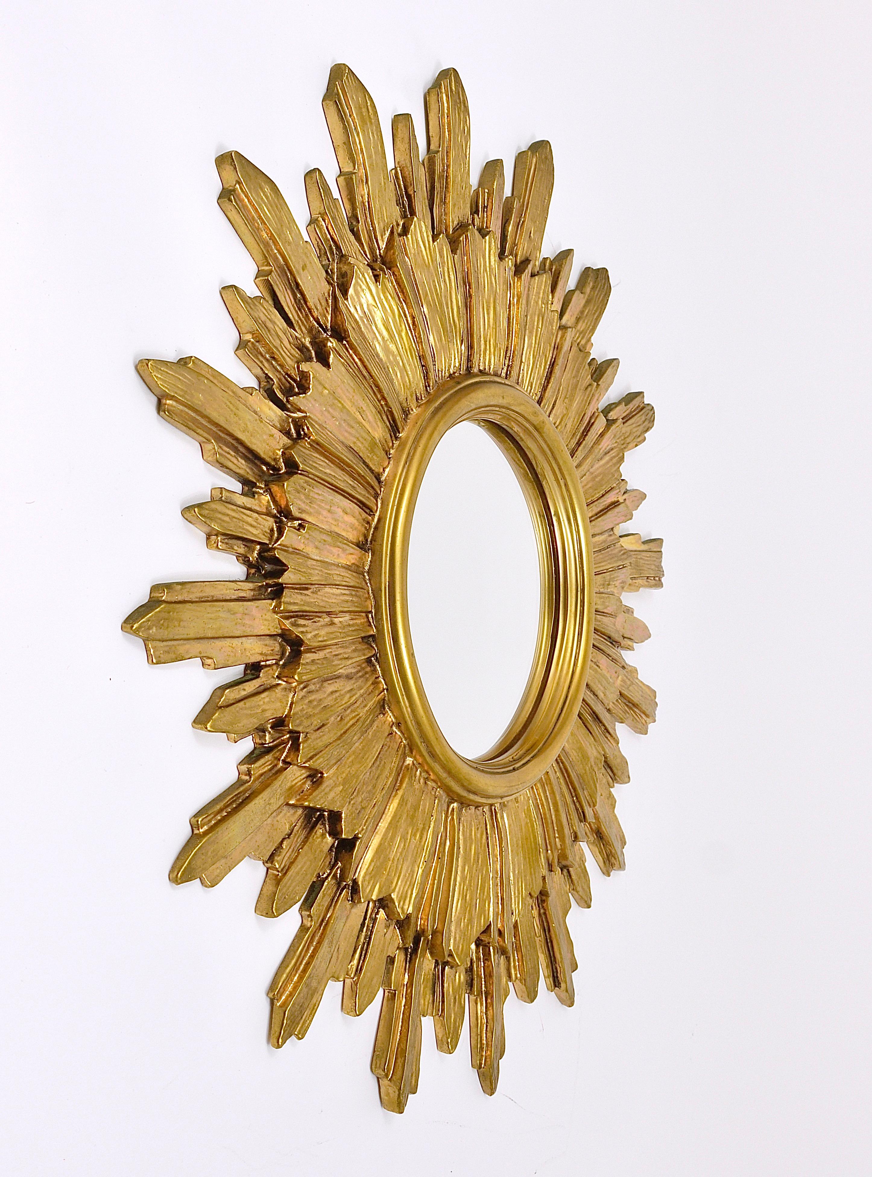 A very beautiful and decorative golden mid-century sunburst starburst mirror. Made in France in the 1960s. Made of resin, in good condition. Total diameter 20“, the diameter of the mirror itself is 6 3/4“.