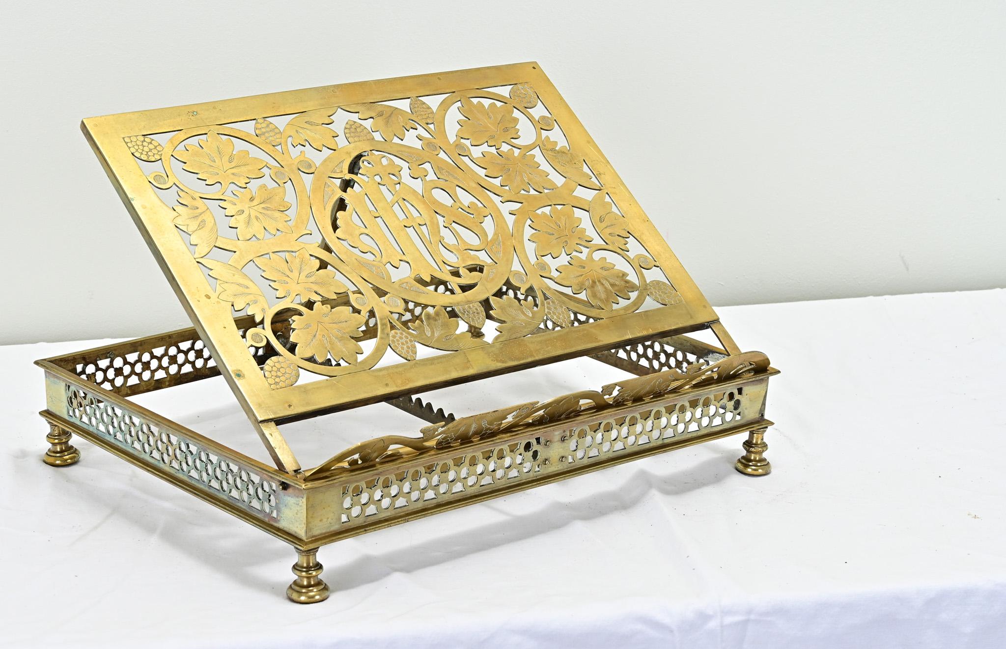 A large decorative brass Bible stand from a Catholic church. This versatile antique book stand has the ability to lay flat or to be used at adjustable angles. The detailed craftsmanship of the pierced brass and etching is impressive and symbolizes