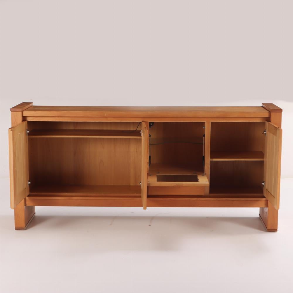 French solid elm sideboard with bar section by Maison Regain, C 1970. This sideboard was just purchased from an estate in France and it features three full size doors, a single drawer and a fall front bar section. It has a very good original finish