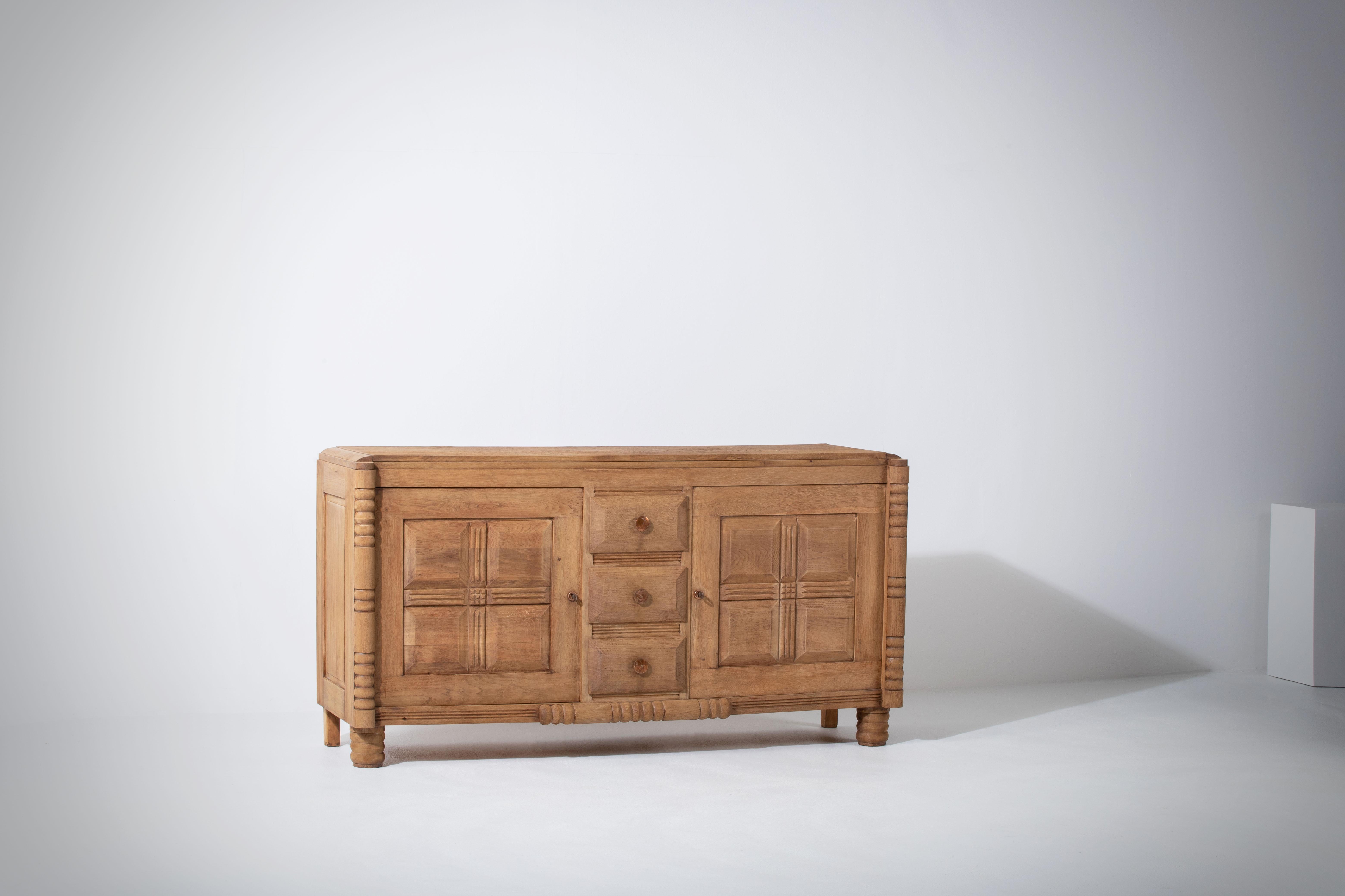 Buffet assorti disponible.
Très élégante crédence en chêne massif, France, années 1940.
Buffet Art Déco Brutalist. 
La crédence se compose de deux rangements habillés de portes au design graphique et d'une colonne de tiroirs.
Les structures en
