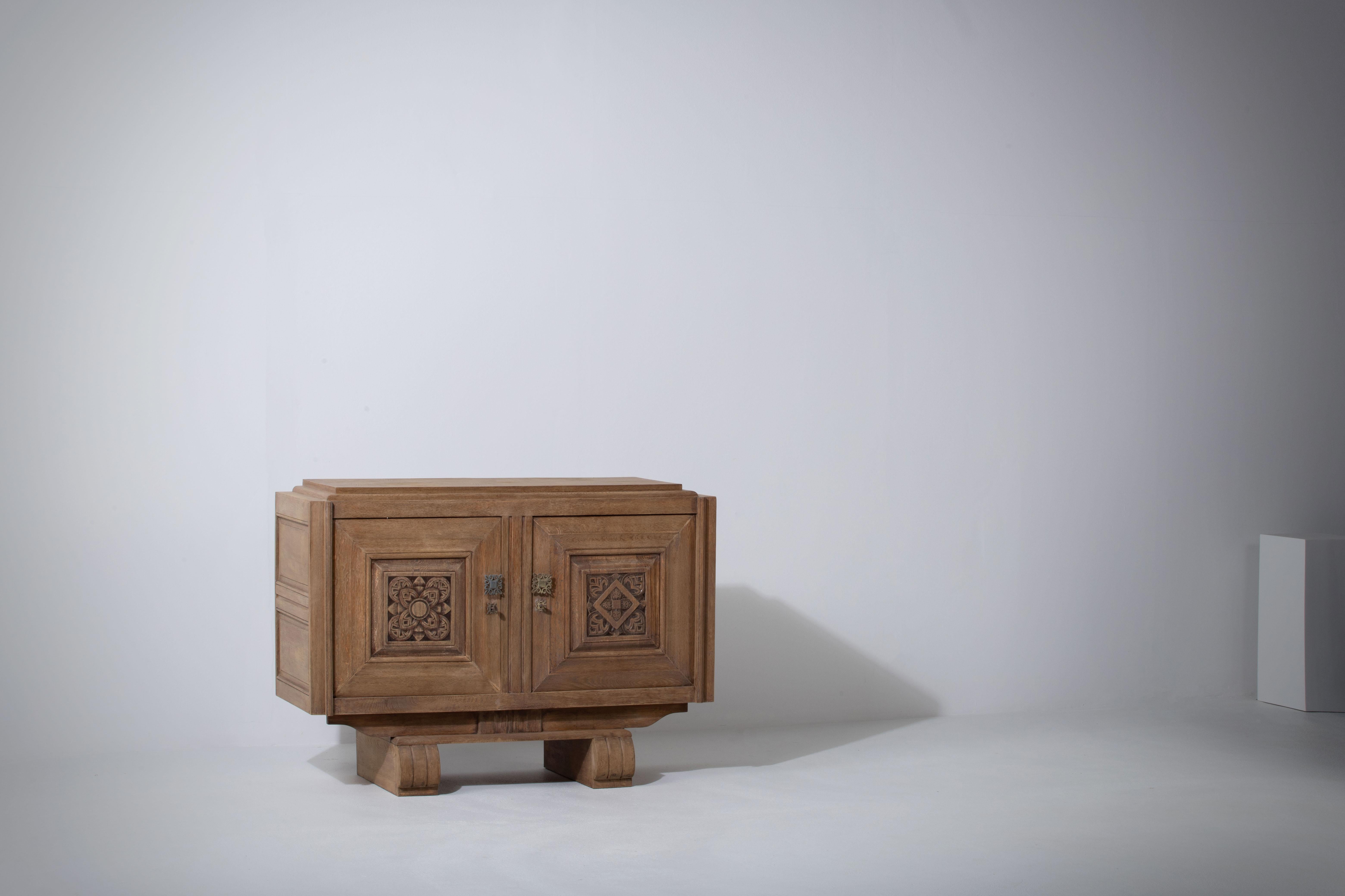 Sehr elegante Credenza aus massiver Eiche, Frankreich, 1940er Jahre.
Brutalistisches Sideboard im Art-Deco-Stil. 
Die Kredenz besteht aus zwei Ablagemöglichkeiten, die mit grafisch gestalteten Türen abgedeckt sind.
Die raffinierten Holzstrukturen