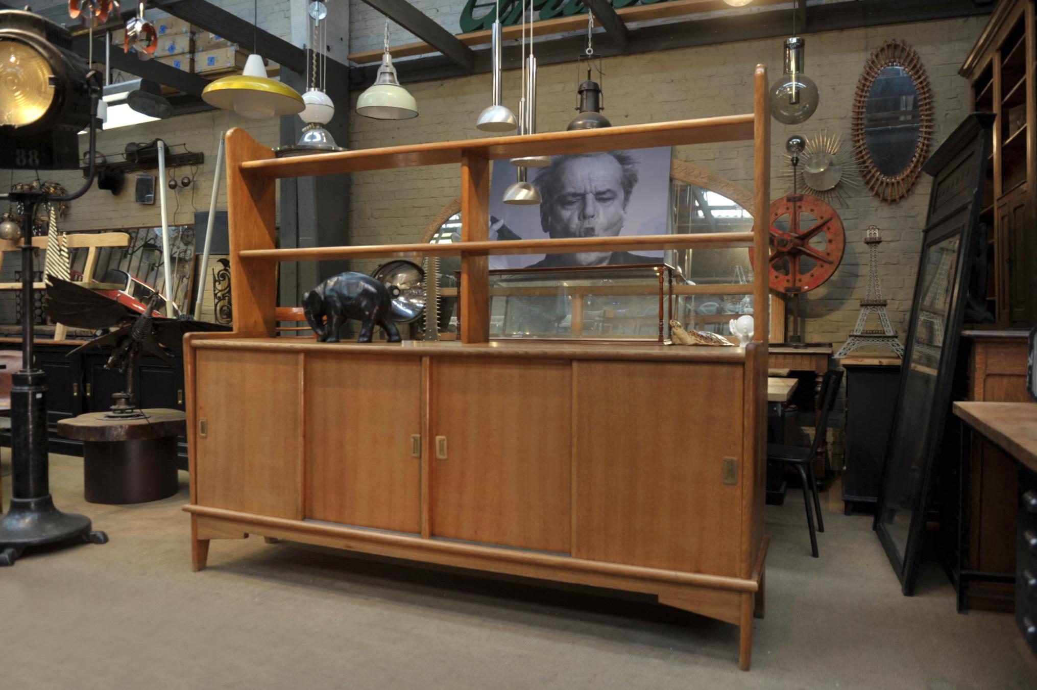 Original shape French solid oak midcentury shelf cabinet, 4 sliding door opening with brass handles very stable and very good condition, circa 1950.