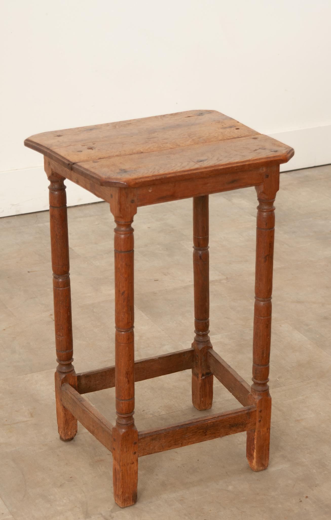 This simply constructed primitive counter stool was crafted from solid oak in France during the 19th century. A great patina envelops the whole. Sturdy and level on wonderfully turned legs. Its height and smooth square top gives the option for use