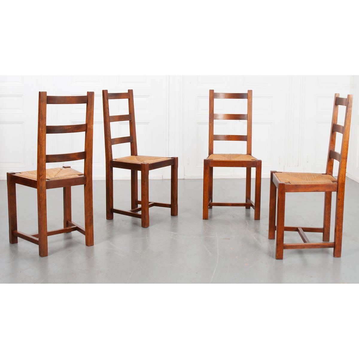 This set of four chairs is French 19th century. They are constructed of solid oak and have removable rush seats which makes the chairs very sturdy. This way over time if the chairs should become loose, you can easily tighten each chair without