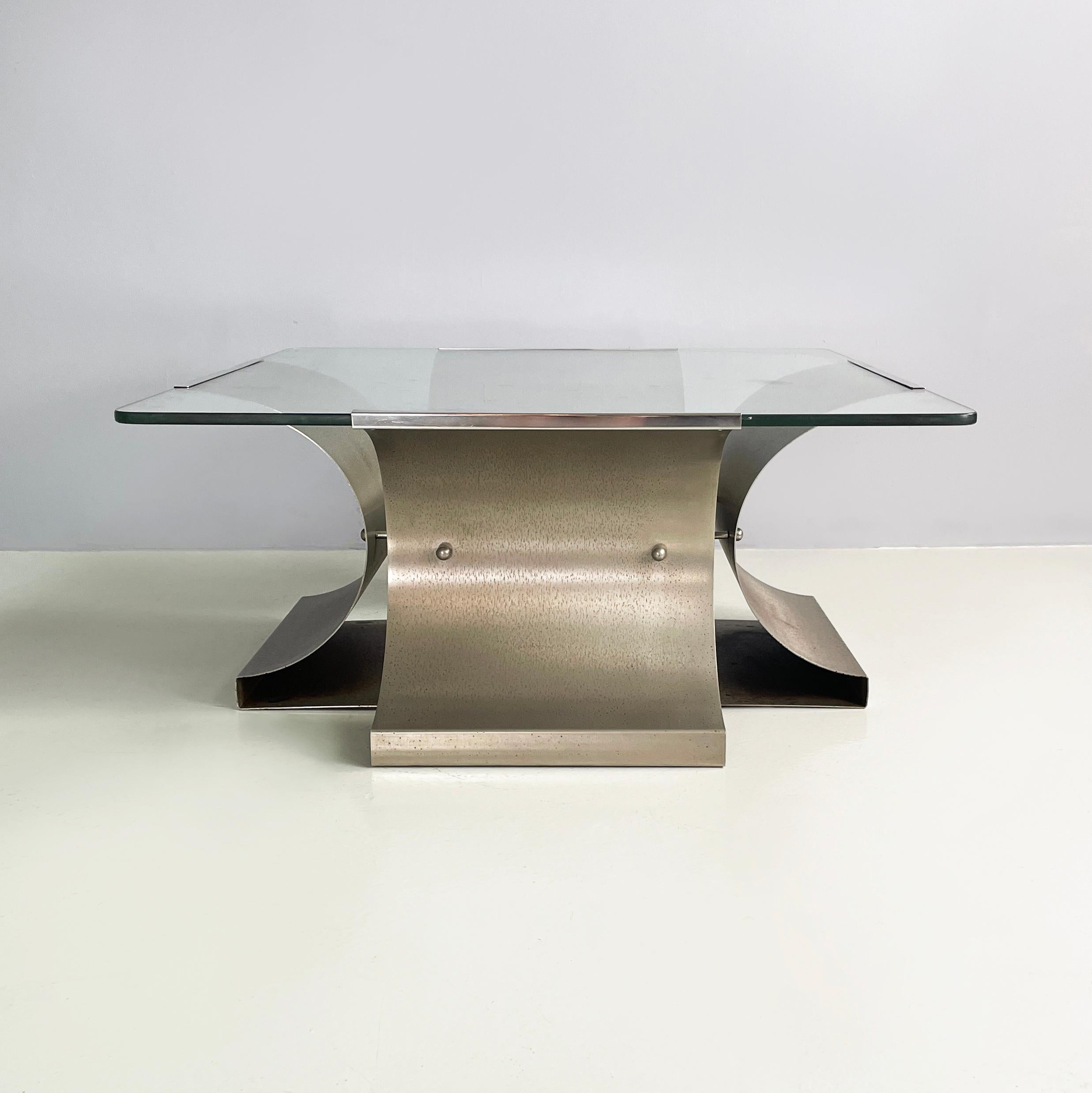 French space age Coffee table by Francois Monnet for  Kappa, 1970s
Coffee table with square transparent glass top with rounded corners. The structure is made up of 4 brushed and curved steel sheets, positioned in a cross shape. The 4 sheets are