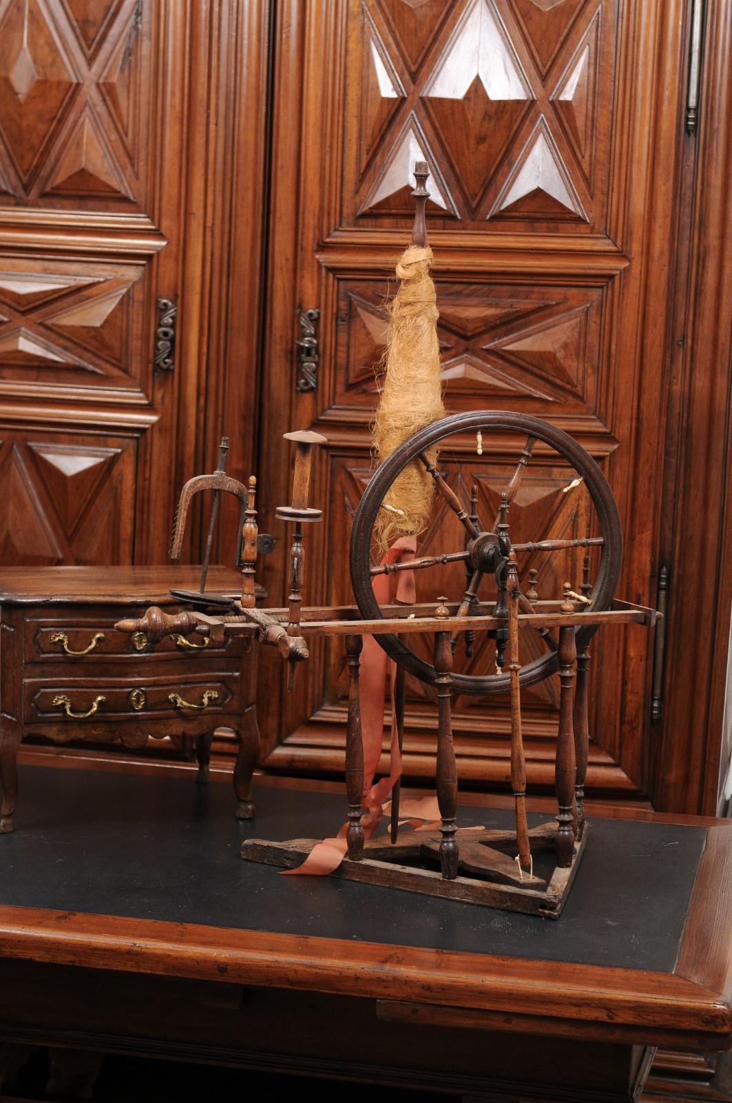 A French rustic spinning wheel from the 18th century, with original parts. Created in France during the 18th century, this spinning wheel will be an excellent decorative addition to any home. The wheel, connected to the treadle thanks to a turned