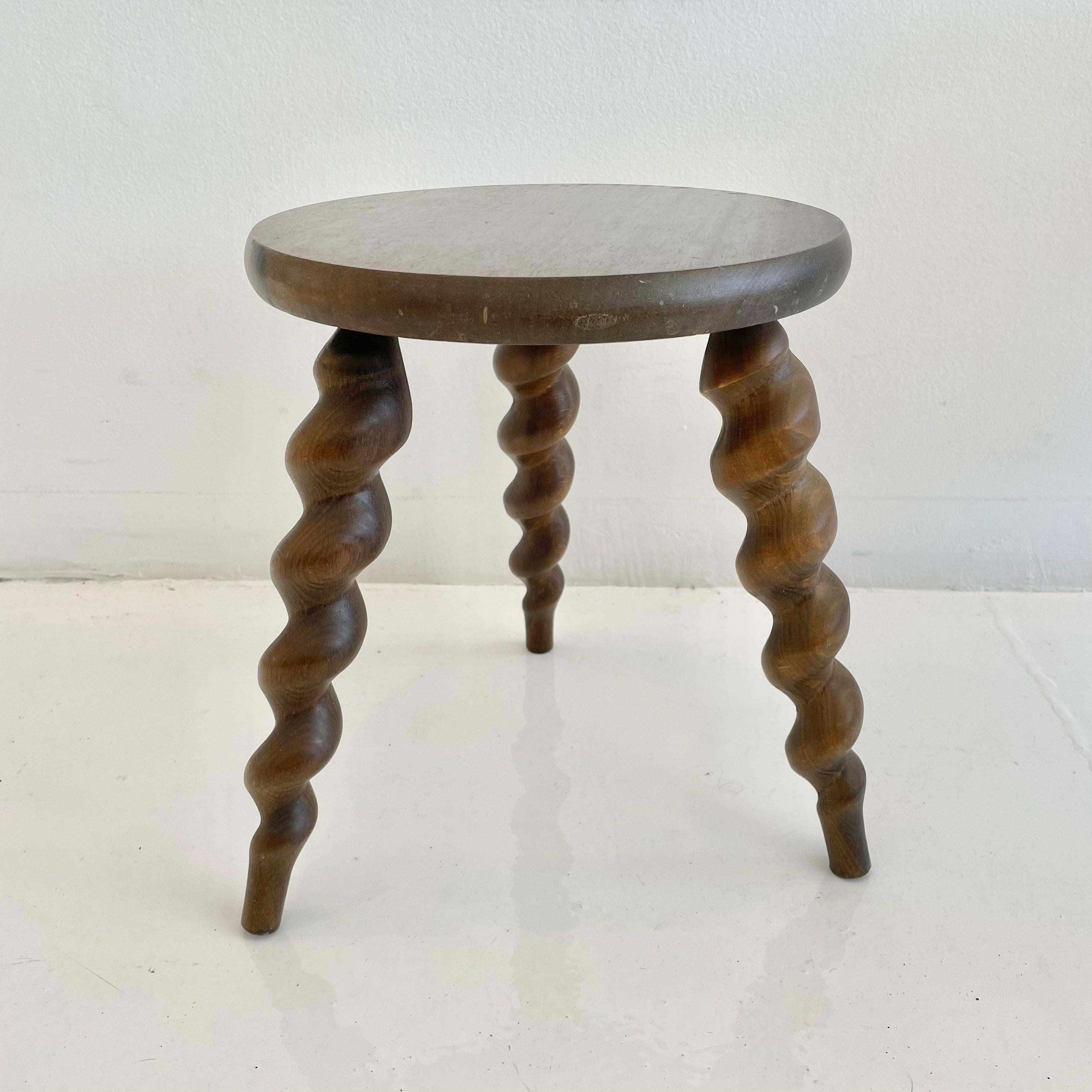 Beautiful wooden stool made in France, circa 1950s. Amazing craftsmanship on spiral legs. Great patina and grain to the dark wood. Excellent petite shape and tapered legs. Perfect for books or objects.
 