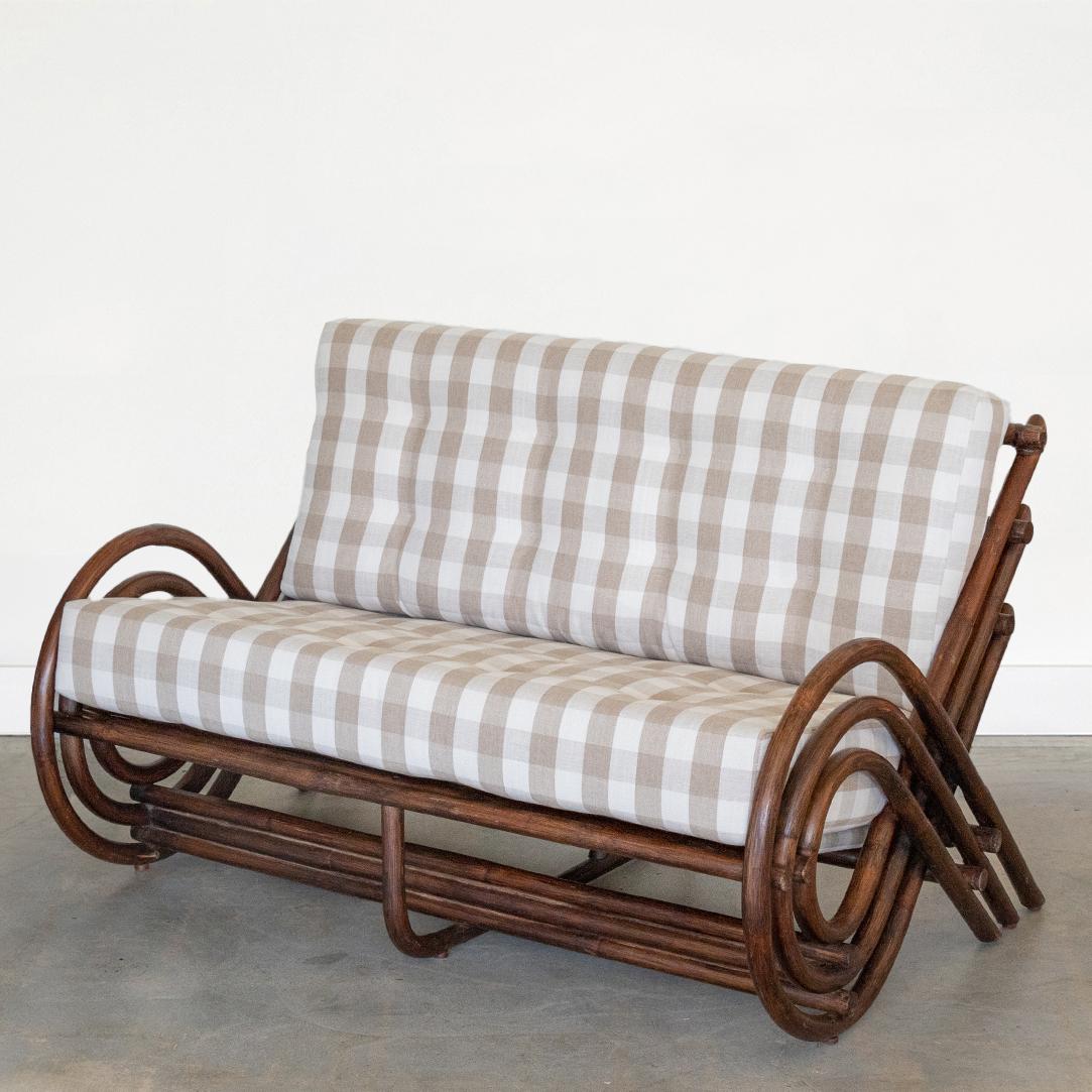 Incredible rattan spiral settee from France, 1970's. Beautiful spiraled rattan arms and slatted back. Original dark brown coloring with leather wrapped ties on corners. New cushions upholstered in a neutral linen/ cotton plaid. Rare and stunning