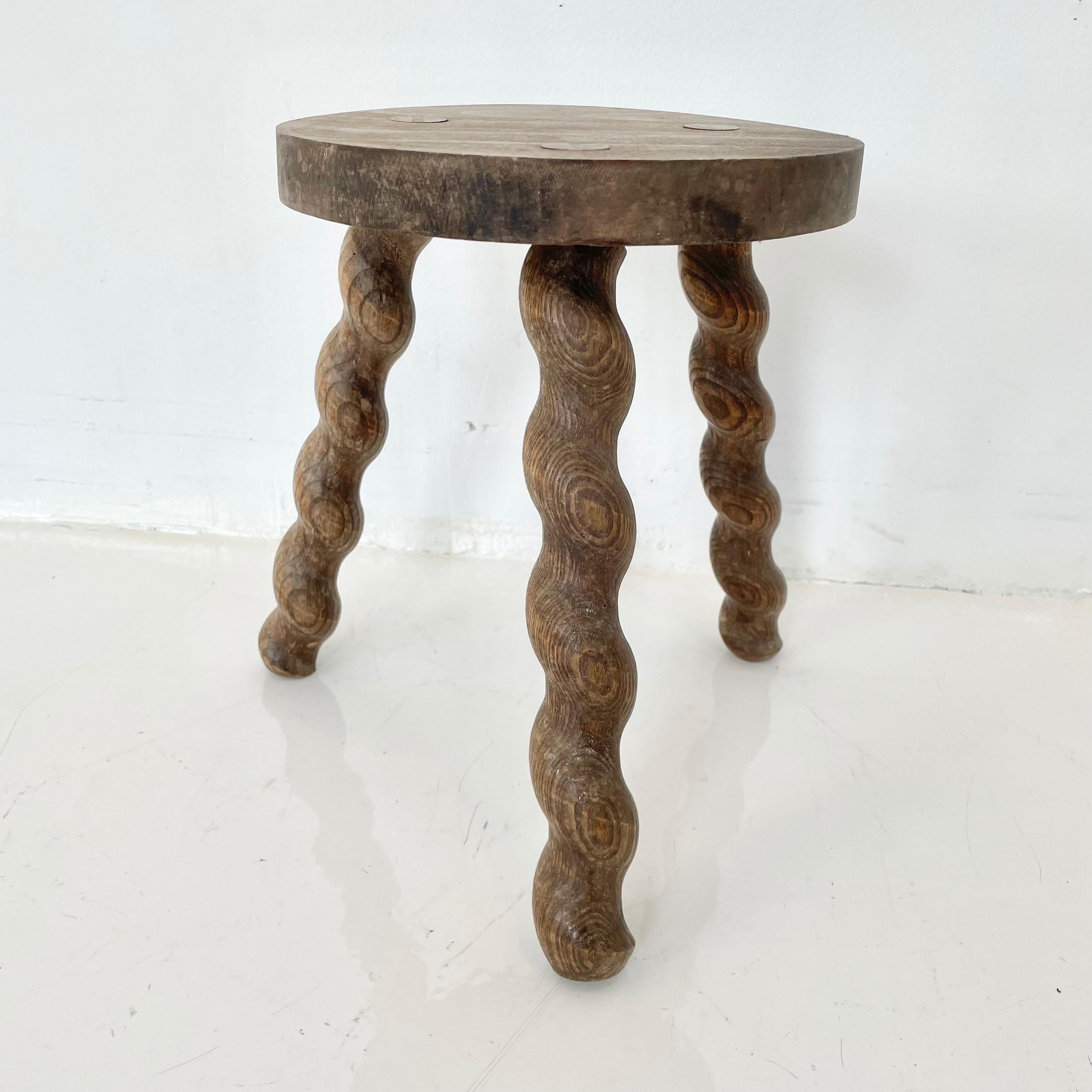 Unusual wooden milking stool made in France, circa 1950s. Thick seat with three spiral legs. No nails or hardware. Stunning lines and shape. Petite stool with great presence. Great vintage condition.
 