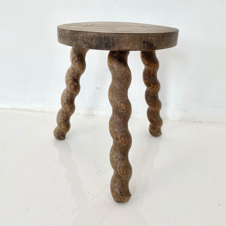 Unusual wooden milking stool made in France, circa 1950s. Thick seat with three spiral legs. No nails or hardware. Stunning lines and shape. Petite stool with great presence. Great vintage condition.
 