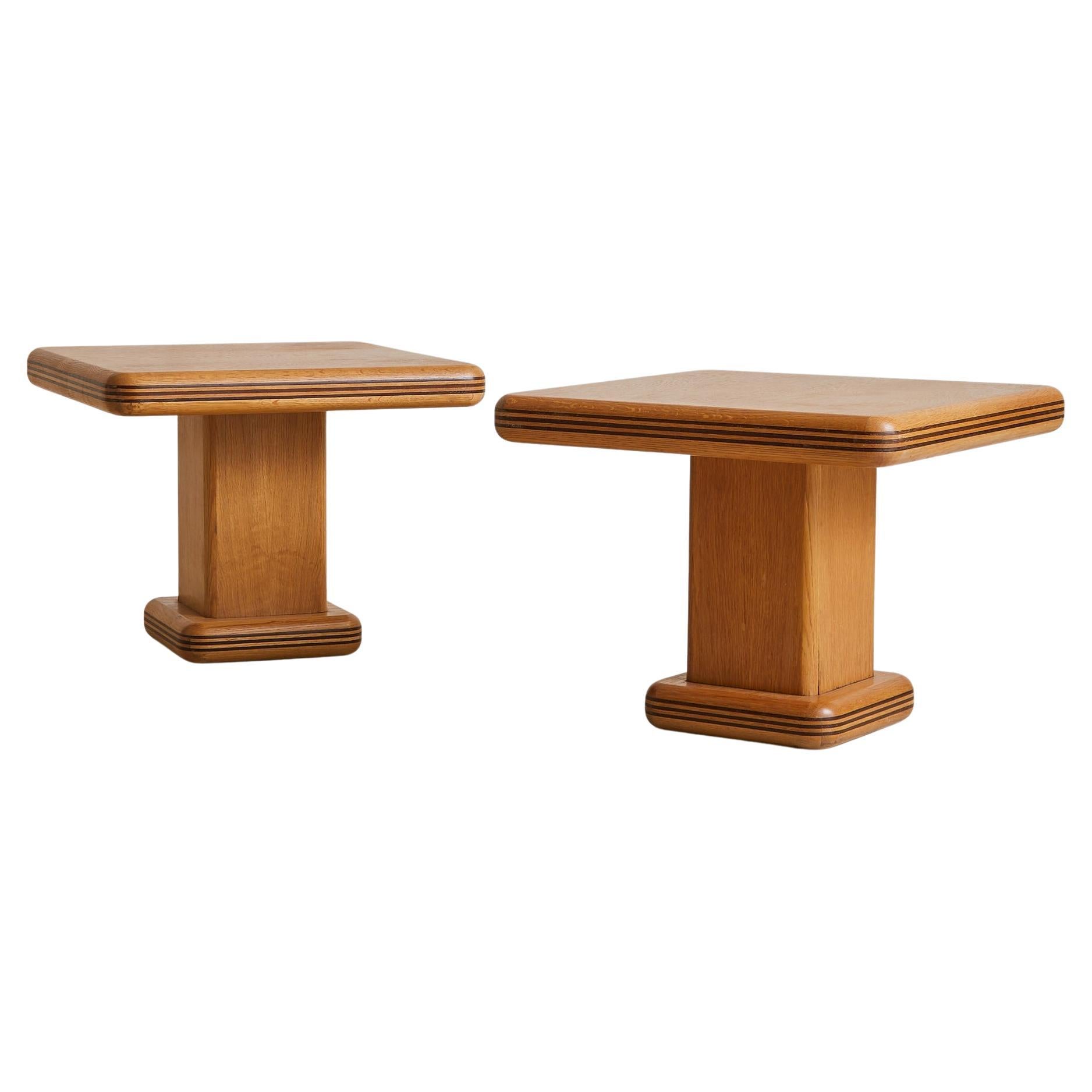 Sold and priced individually.

Sourced in the south of France and crafted in the 1960s, this square side table is rendered in warm, honey-toned oak with a distinctive rhythm of inlaid dark wood bands. The top rests on a central pedestal with