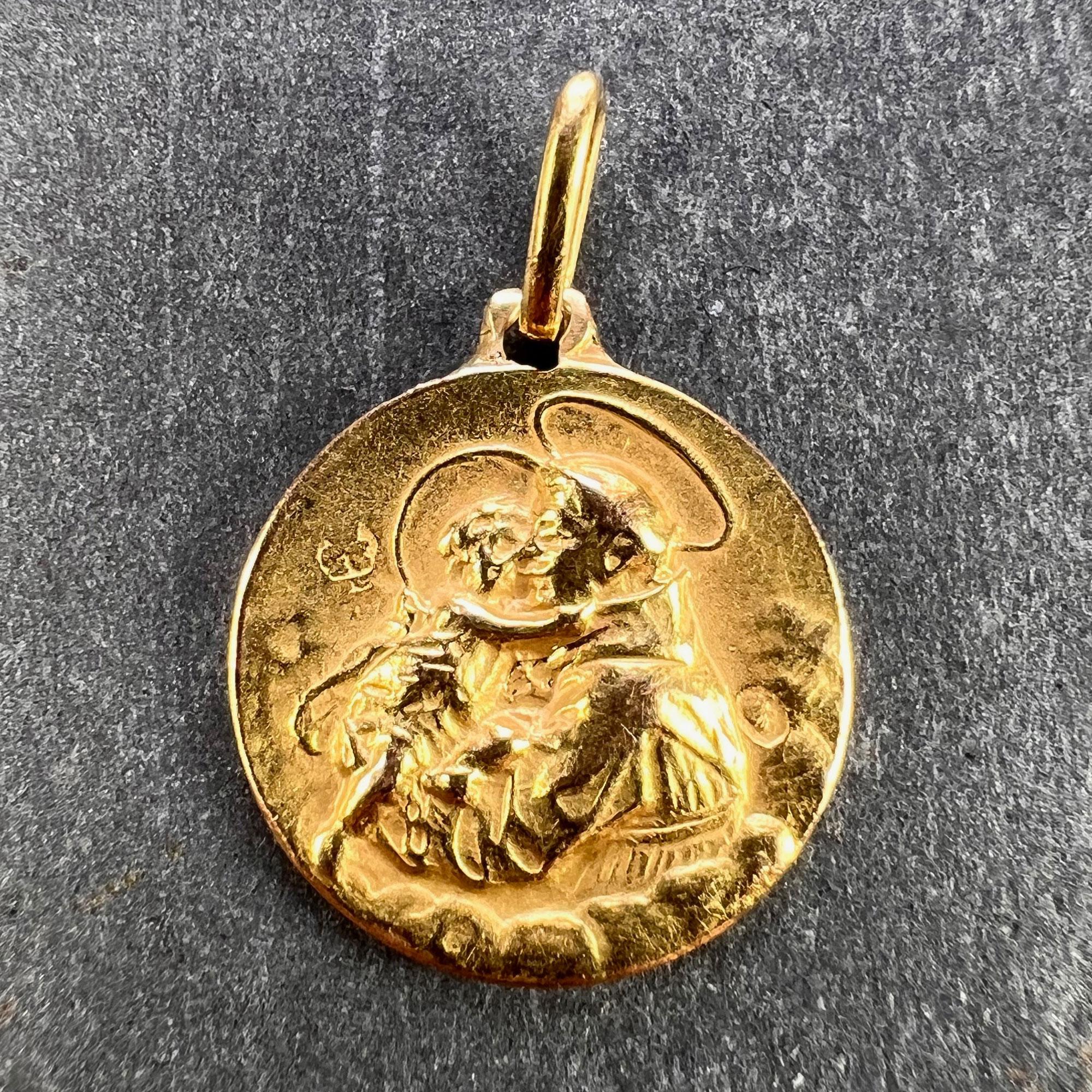 A French 18 karat (18K) yellow gold charm pendant designed as a medal depicting St Christopher carrying the infant Christ across a river. Partially stamped with the eagle’s head for French manufacture and 18 carat gold.

Dimensions: 1.5 x 1.4 x 0.15
