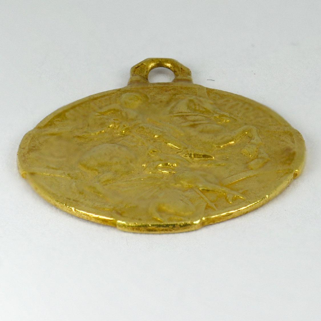 A French 18 karat (18K) yellow gold charm pendant designed as a medal depicting St George defeating the dragon. The reverse depicting a ship with ‘In Tempestate Securitas’, monogrammed GB and dated 5-7-1951. Stamped with the eagle’s head for 18