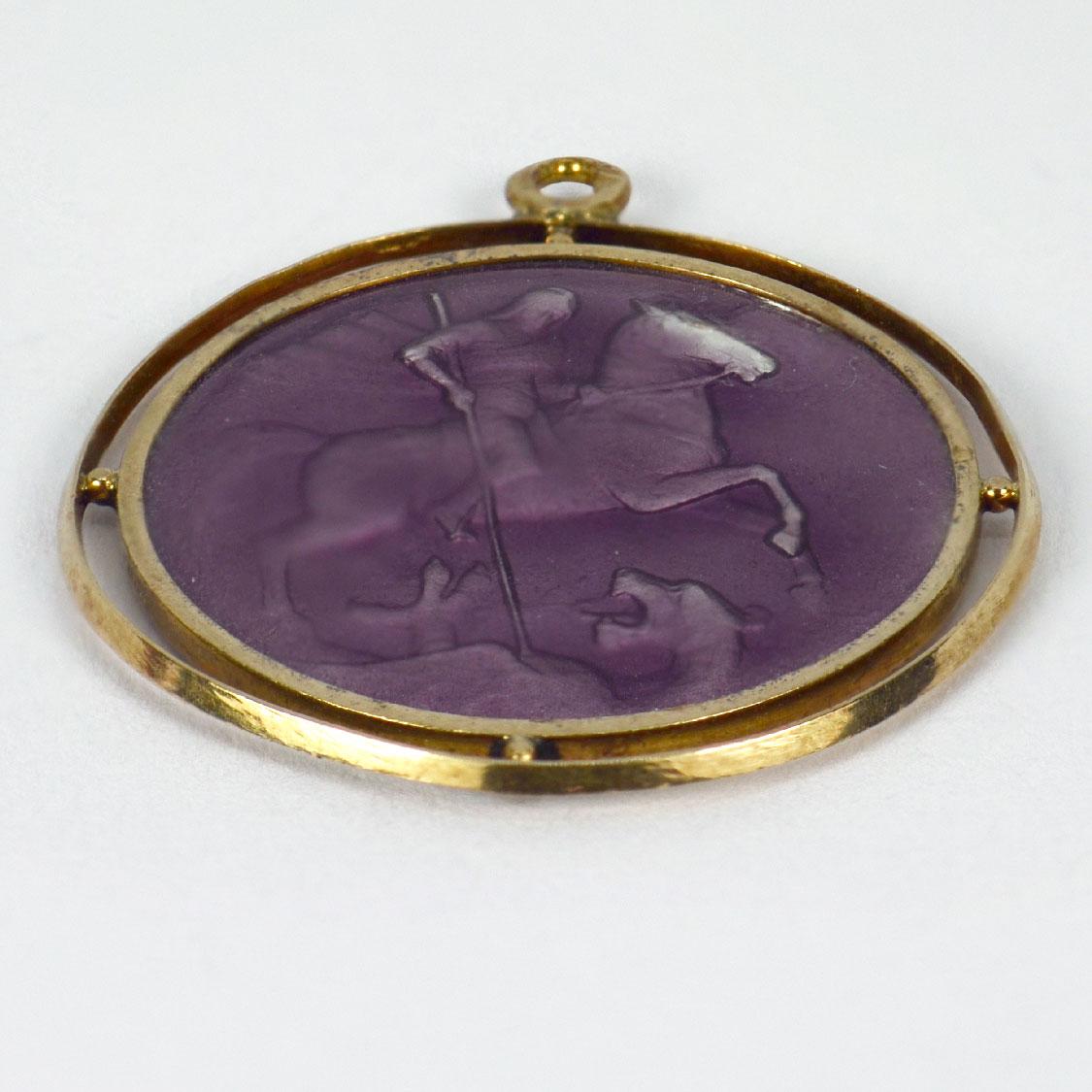 An 18 karat (18K) yellow and white gold pendant designed as a round medal depicting St George defeating the Dragon. With purple enamel and guilloche enamel reverse. Stamped with the eagle’s head for French manufacture and 18 karat gold. Enamel