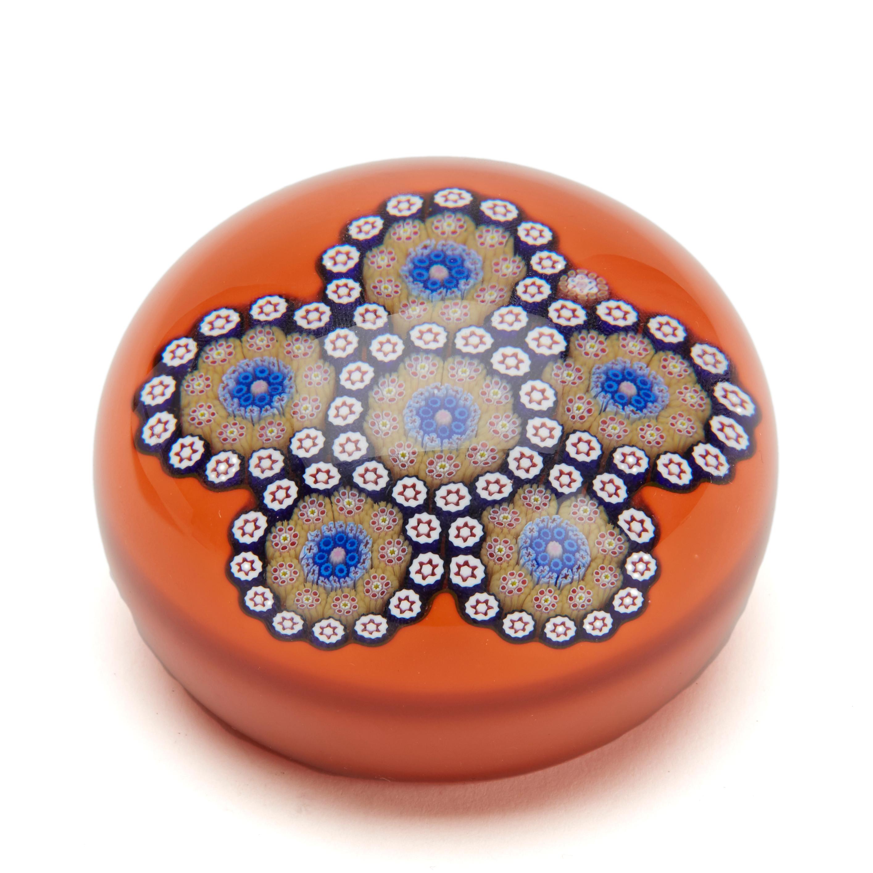 A fine vintage French Saint Louis limited edition Millefiori glass paperweight with a five 'petal' floral arrangement in coloured canes on an orange cushion ground incorporating a signature cane marked SL 1984. The paperweight has its original box