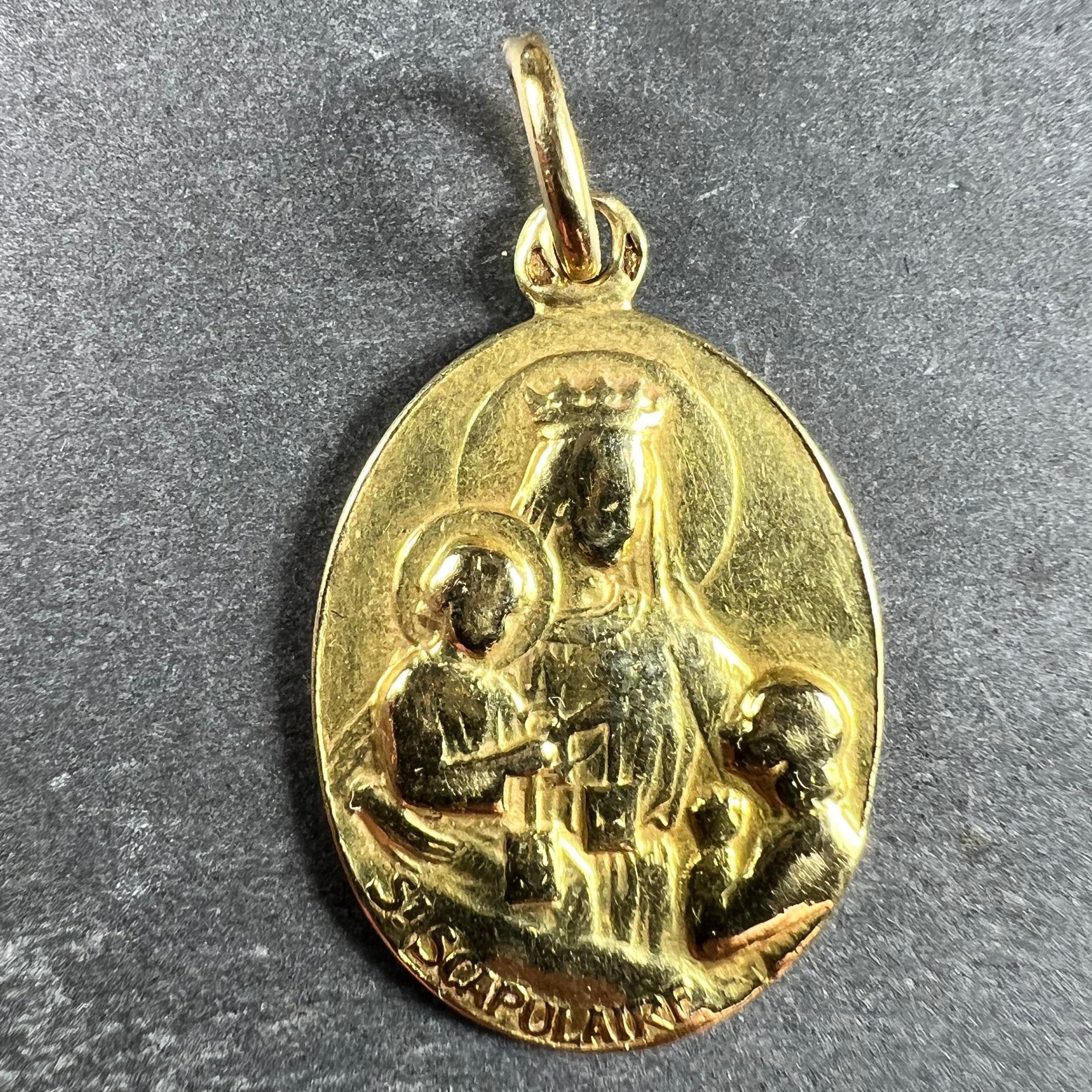 Pendentif à breloques en or jaune 18 carats (18K) conçu comme une médaille ovale avec un relief de la Sainte Vierge Marie en Madone avec le Christ enfant tenant un ensemble de scapulaires de dévotion, tandis qu'un enfant les prie. En dessous, le nom