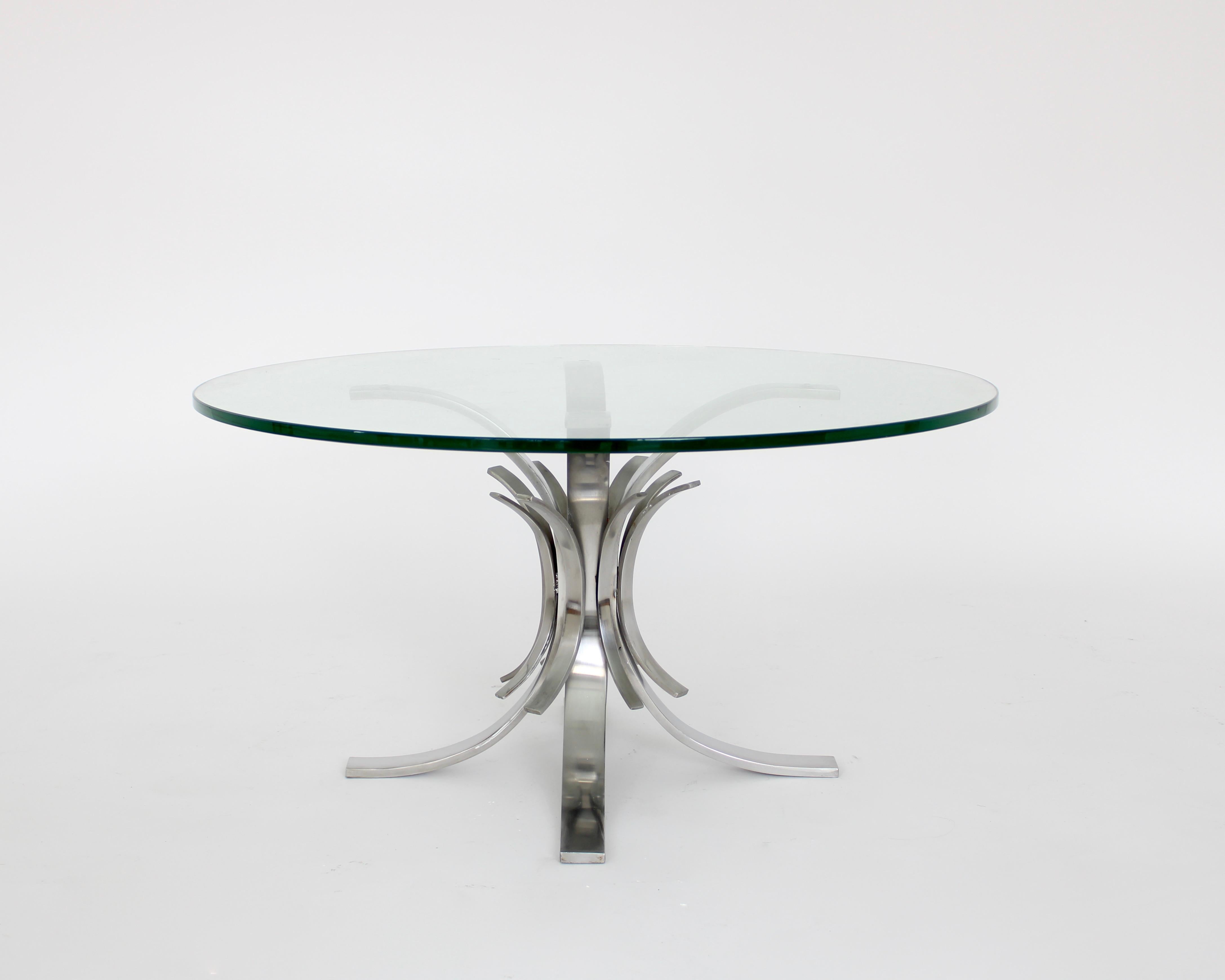 Stainless steel French coffee table attributed to Maria Pergay model Gerbe. 
Flaring pieces of curved stainless steel attached to a central core then support a round glass top. 
Although this exact model is not pictured in the monograph Maria