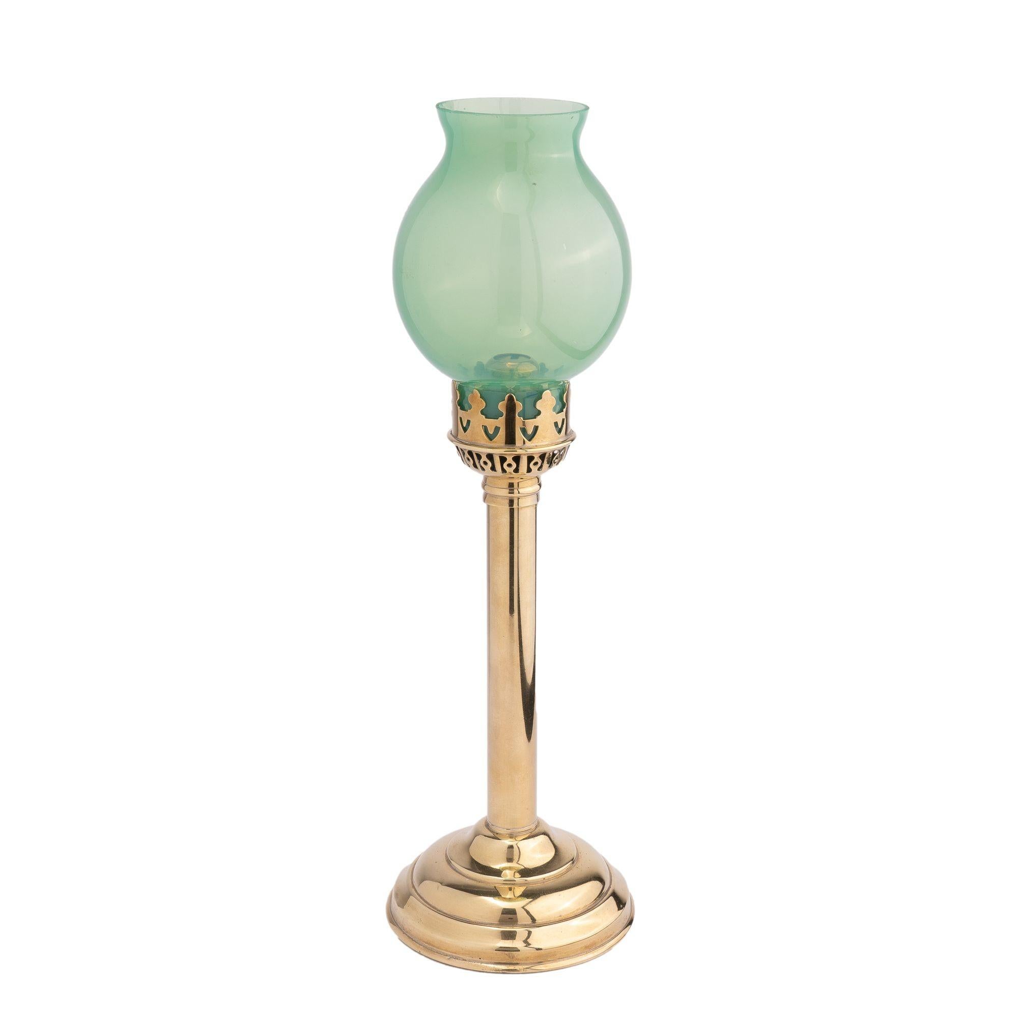 Spring loaded cylinder shaft candlestick in stamped brass on a weighted circular domed base. The candlestick top has a reticulated brass shade gallery fitted with a translucent green opaline blown glass bubble shade.
France, 1875-1900.