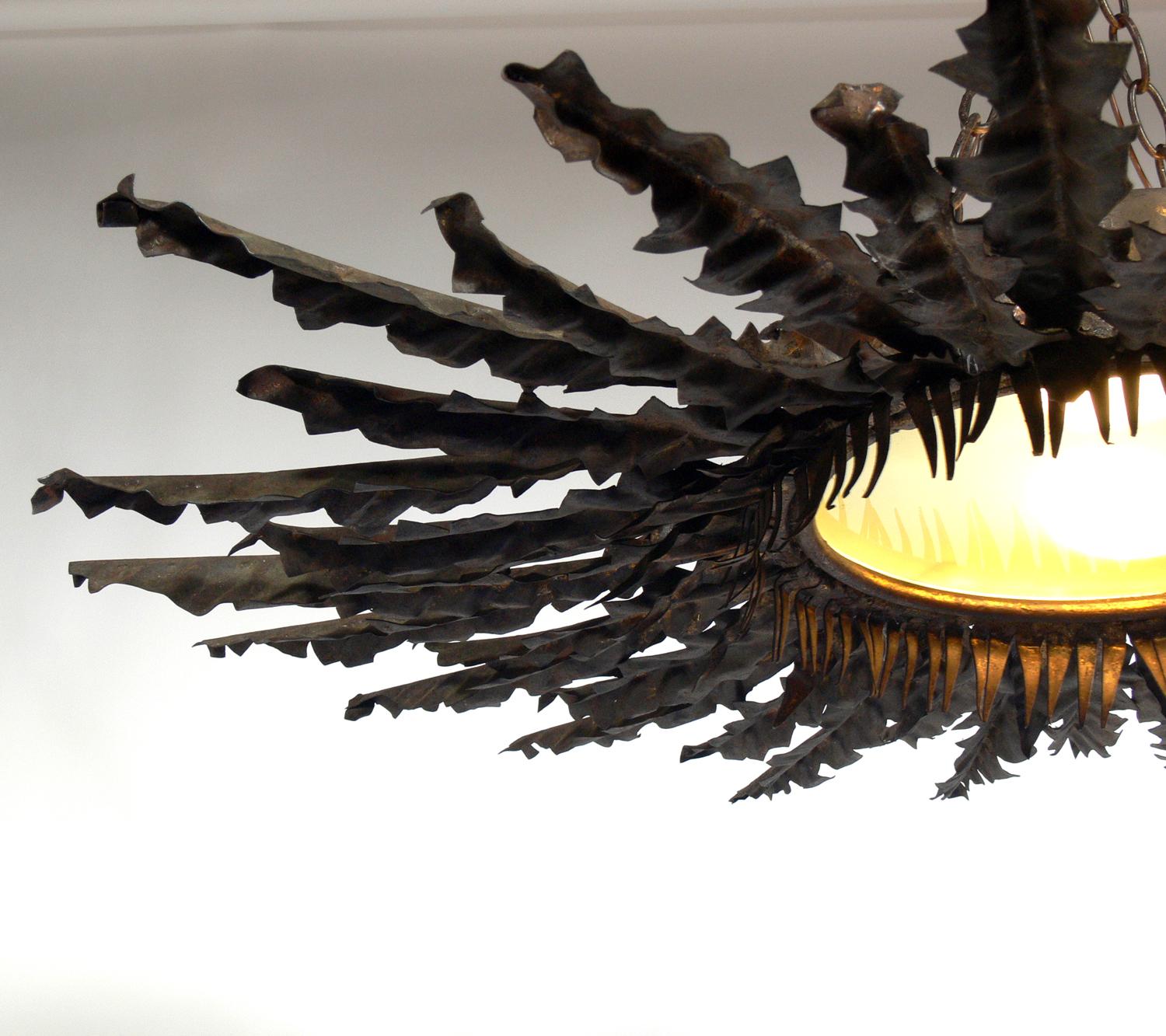 French starburst chandelier, France, circa 1930s. It is constructed of patinated metal, probably copper, but has taken on a bronze color patina, and frosted glass. It has been rewired and is ready to mount.