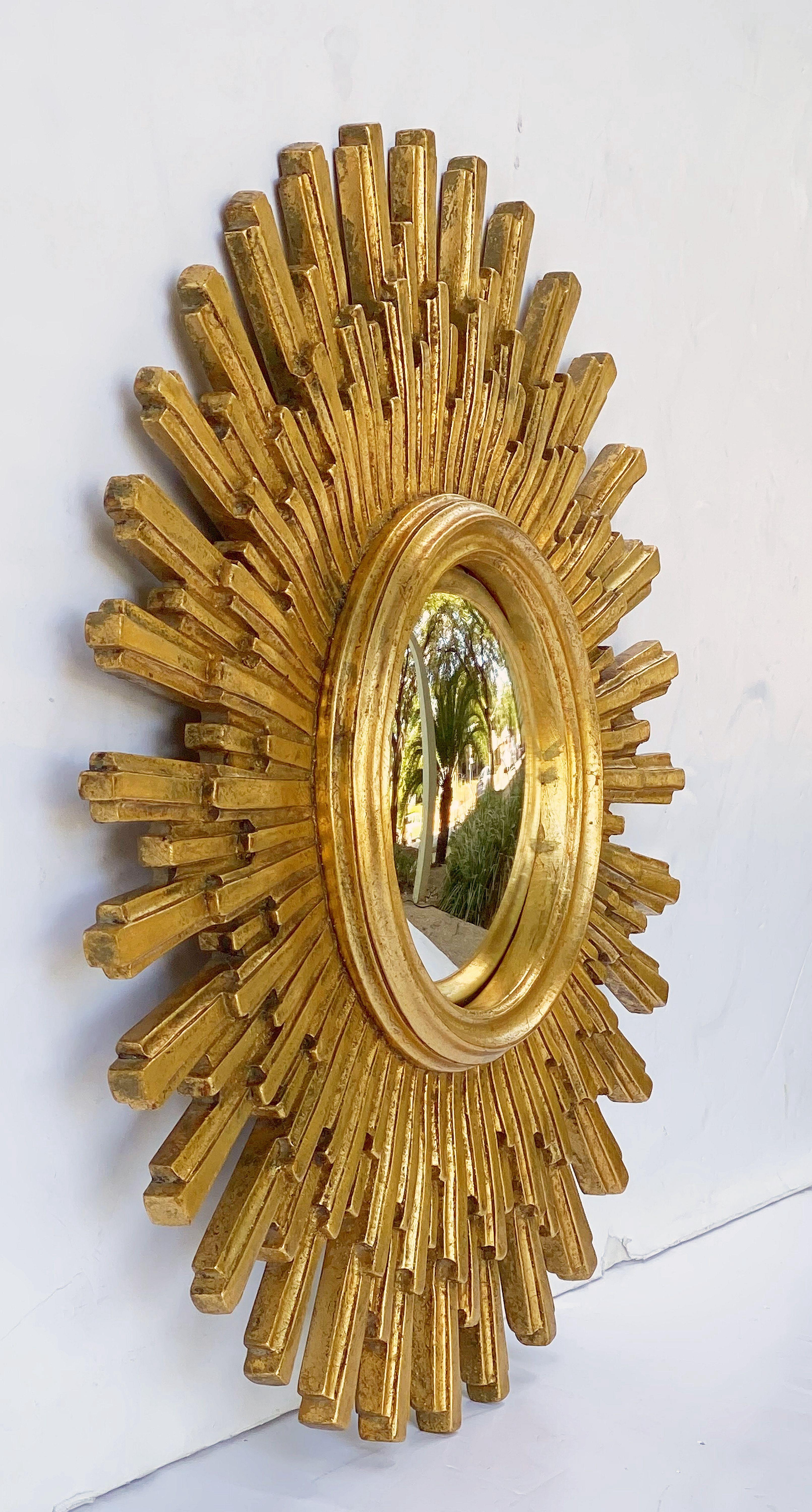 A lovely French gilt sunburst (or starburst) mirror, measures: 22 inches diameter, with round mirrored convex glass center in a moulded cast frame.