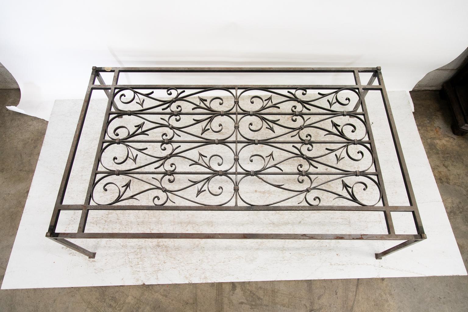 The central panel of this coffee table is an old French iron work that has had a custom built frame and legs. One panel has a missing arrow and arabesque. It is offered without a top so the buyer can choose between glass or acrylic. (not included).
