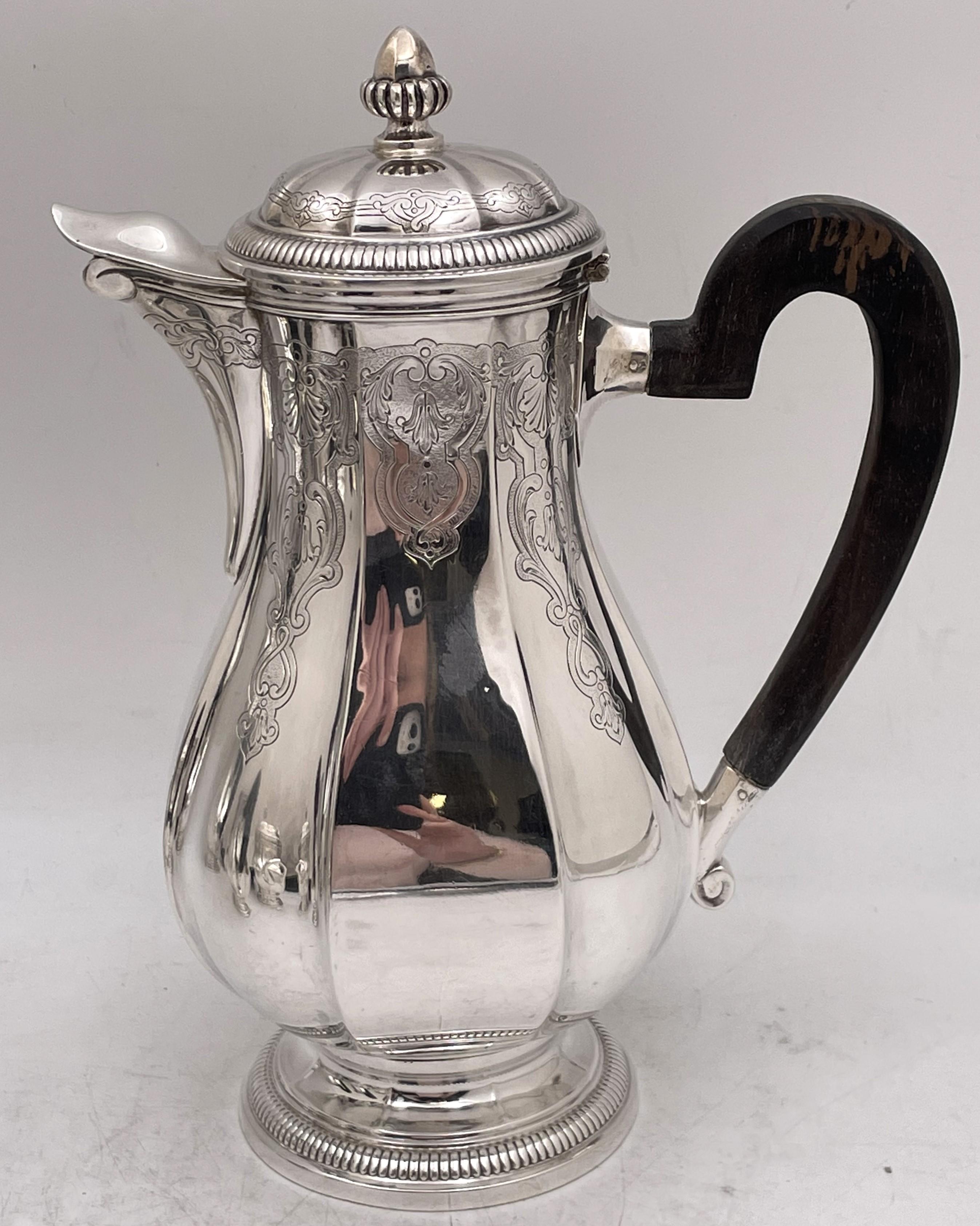 French 0.950 (higher purity than sterling) silver 4-piece tea and coffee set in Art Deco style from the early 20th century, finely engraved with elegant, geometric motifs, with wood handles, consisting of:

- a coffee pot measuring 9 3/4'' in height