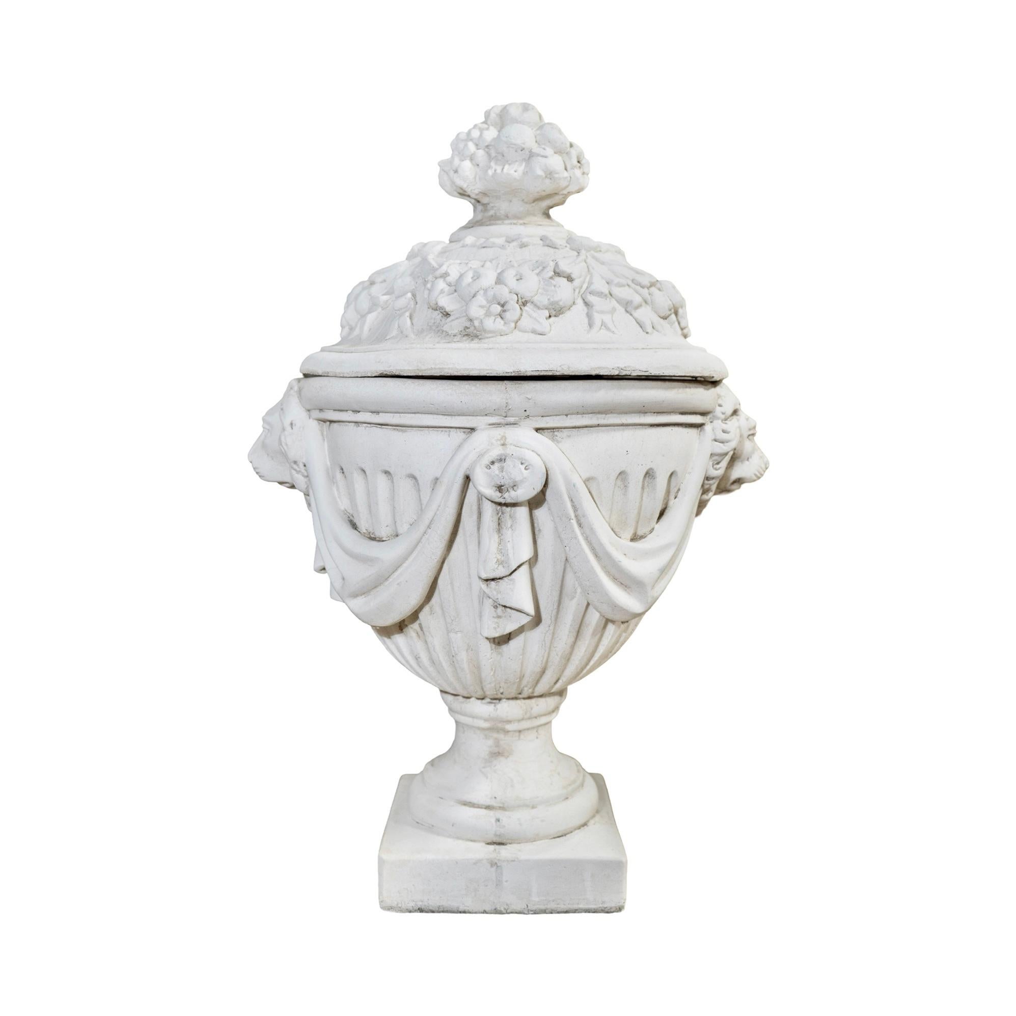 The French Decor Urn is a mid-century contemporary planter from France. Its intricate style carvings, fluted design, and swag style carvings make it a beautiful addition to any garden or outdoor space. Made with a composite stone material, this urn
