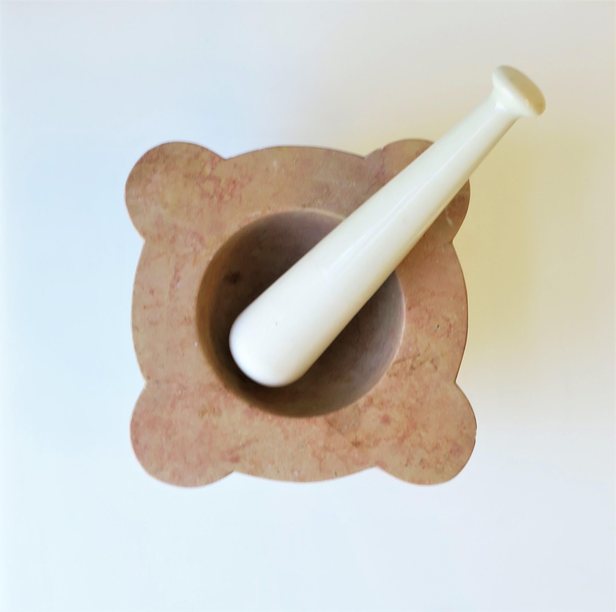 A substantial French stone mortar and pestle set, circa late-20th century, France. Mortar is a light coral/salmon hue with white pestle. A necessity for any kitchen or bar. Polished interior with a matte unpolished exterior. Piece is well made as