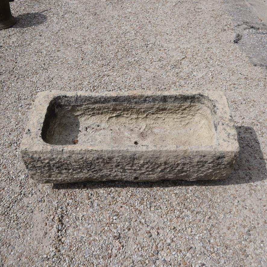 Una mangiatoia potente e scultorea, ricavata a mano da un unico, formidabile blocco di pietra calcarea francese. Questo pezzo non è semplicemente un pezzo d'antiquariato: è una testimonianza del passare del tempo, che incarna un profondo senso della