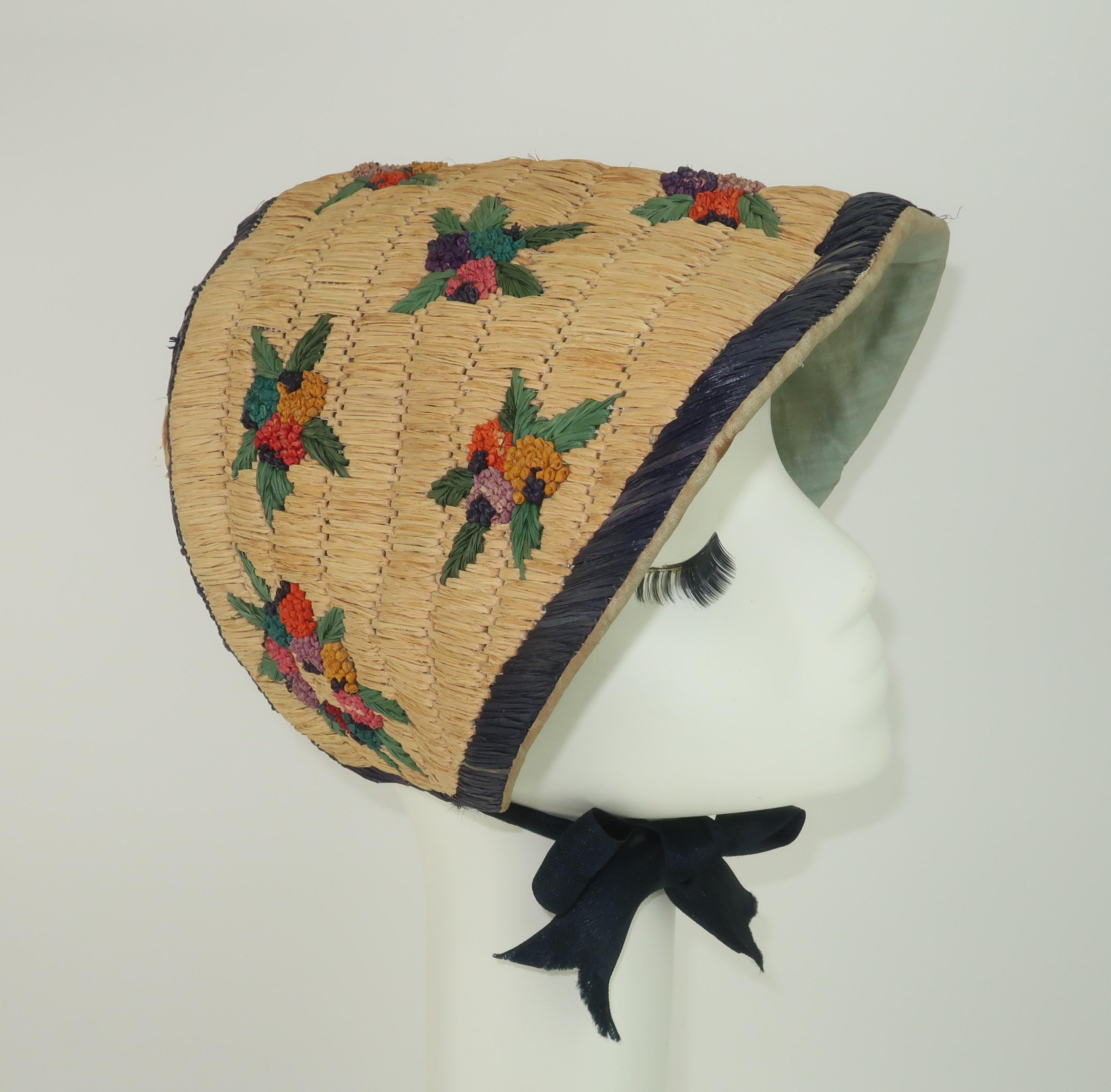1930's charming straw bonnet with raffia embroidered floral motif made in France for the prominent 5th Avenue New York department store, Franklin Simon and their 'Petit Chapeau Shop'.  The bonnet is lined in a fine cotton and sports satin woven chin