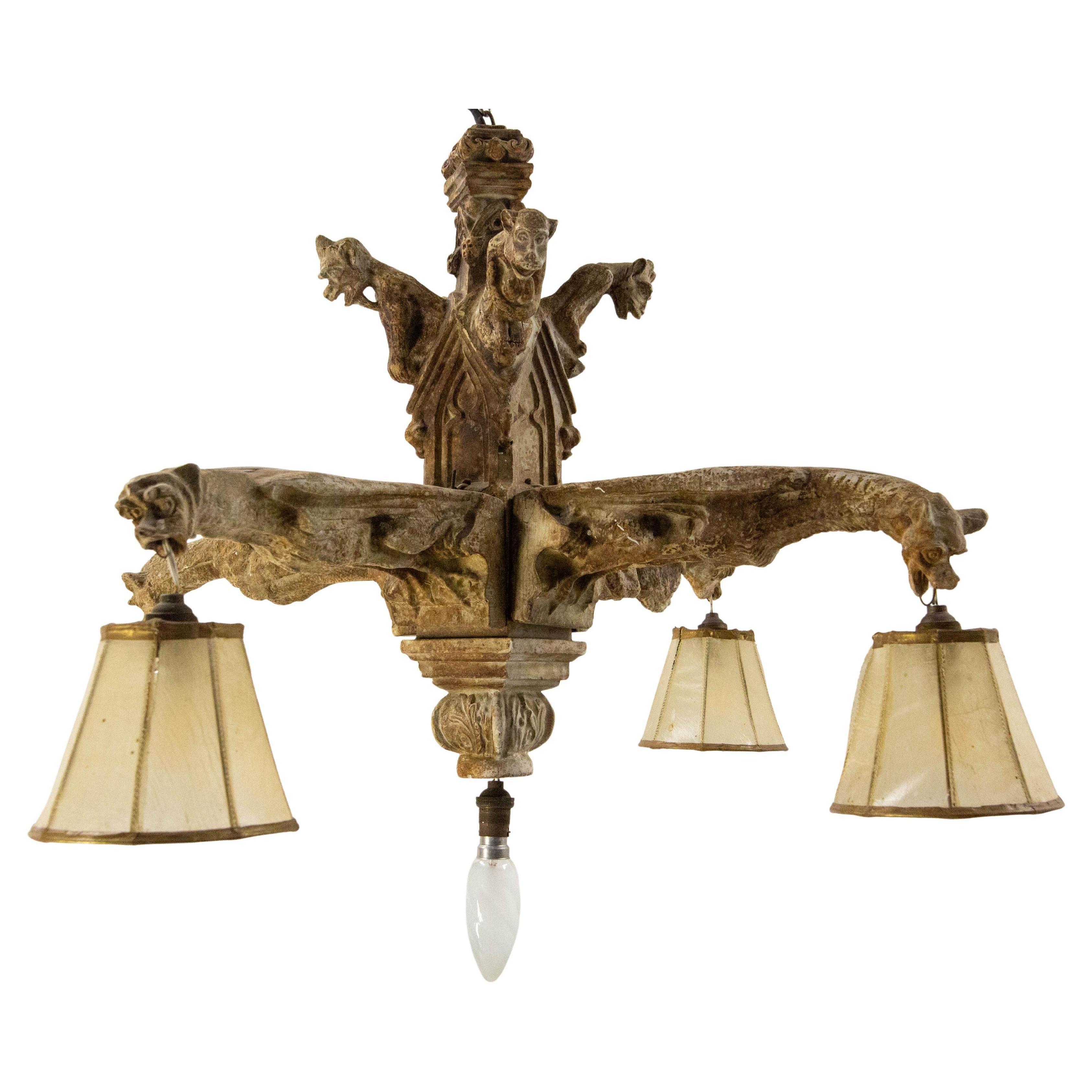 Grande lampadario neogotico in stucco con patina di pietra antica, raffigurante quattro gargoyle grandi e quattro piccole.
Le piccole gargolle o chimere in cima alla sospensione sono inginocchiate o accovacciate. Le quattro grandi gargolle si