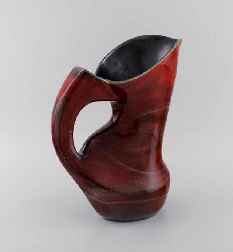 French studio ceramicist. Large abstract unique jug in glazed stoneware. 
Beautiful glaze in shades of red. 1960s / 70s.
Measures: 29 x 23 cm.
In excellent condition.
Signed.