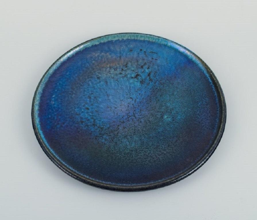 Studio de céramistes français, plat unique en céramique à l'émail cristal avec des nuances de bleu.
Environ les années 1960/70.
En parfait état.
D 28,0 cm.
Signé indistinctement.
