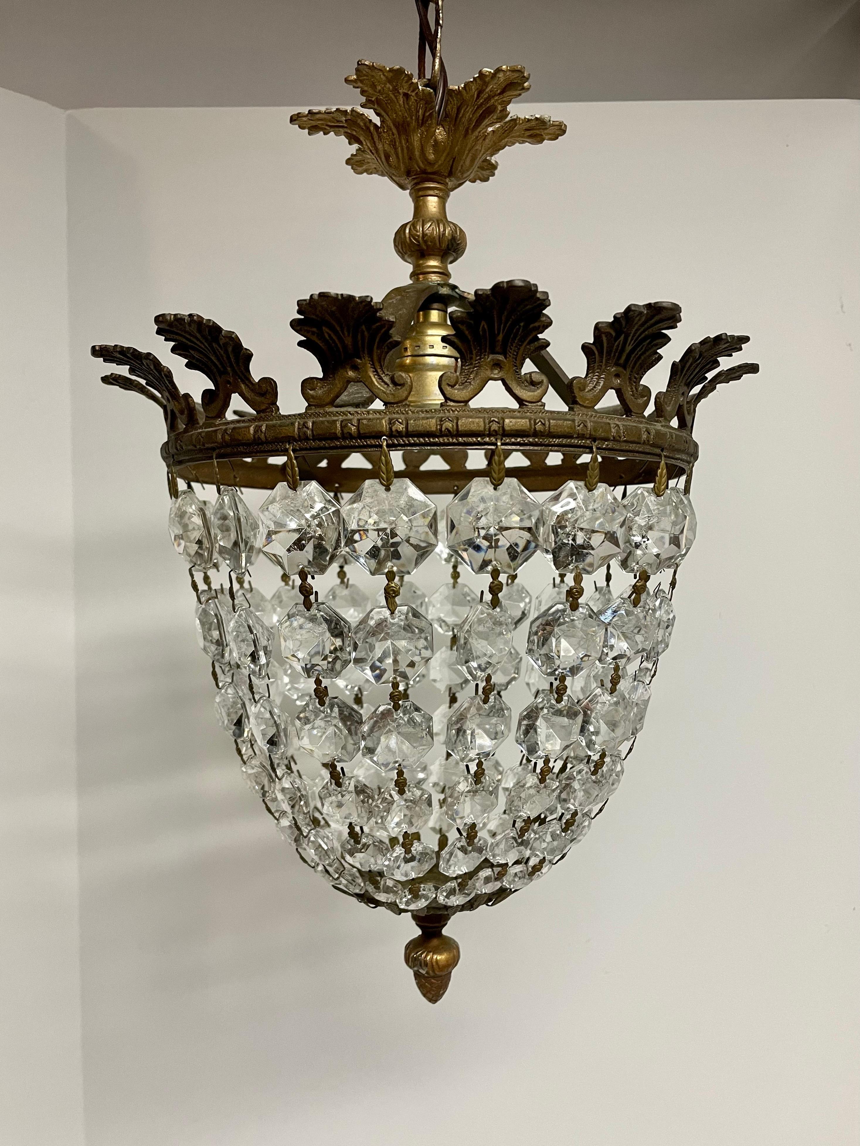 Bronze and Crystal French Style Chandelier featuring shimmering graduated size crystal chains mounted on a detailed bronze frame. Rewired with brown wire and brass medium base socket. Chandelier measures 10.5