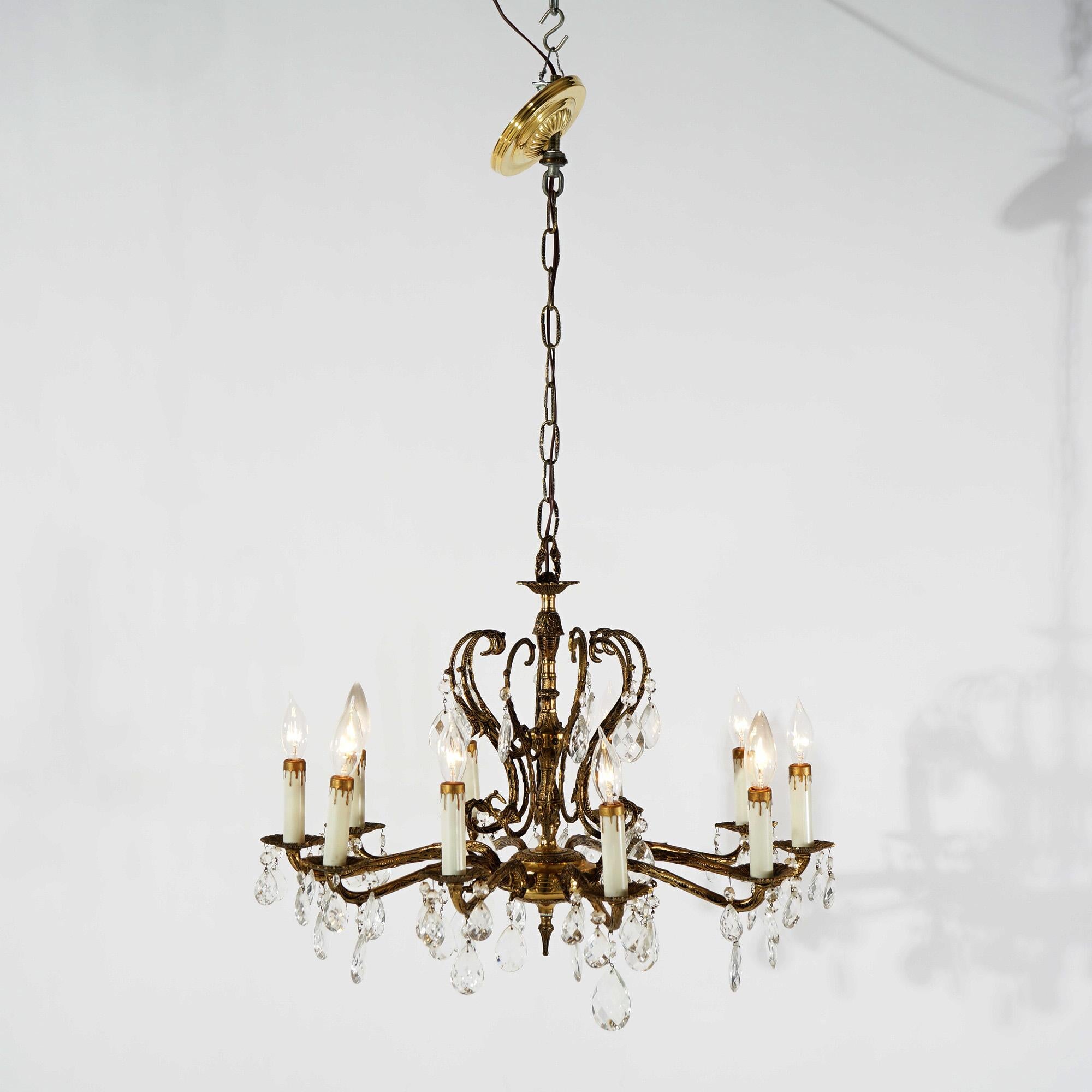 A French style chandelier offers bronzed metal frame with scroll form arms terminating in ten candle lights, hanging crystals throughout, circa 1940

Measures - 36